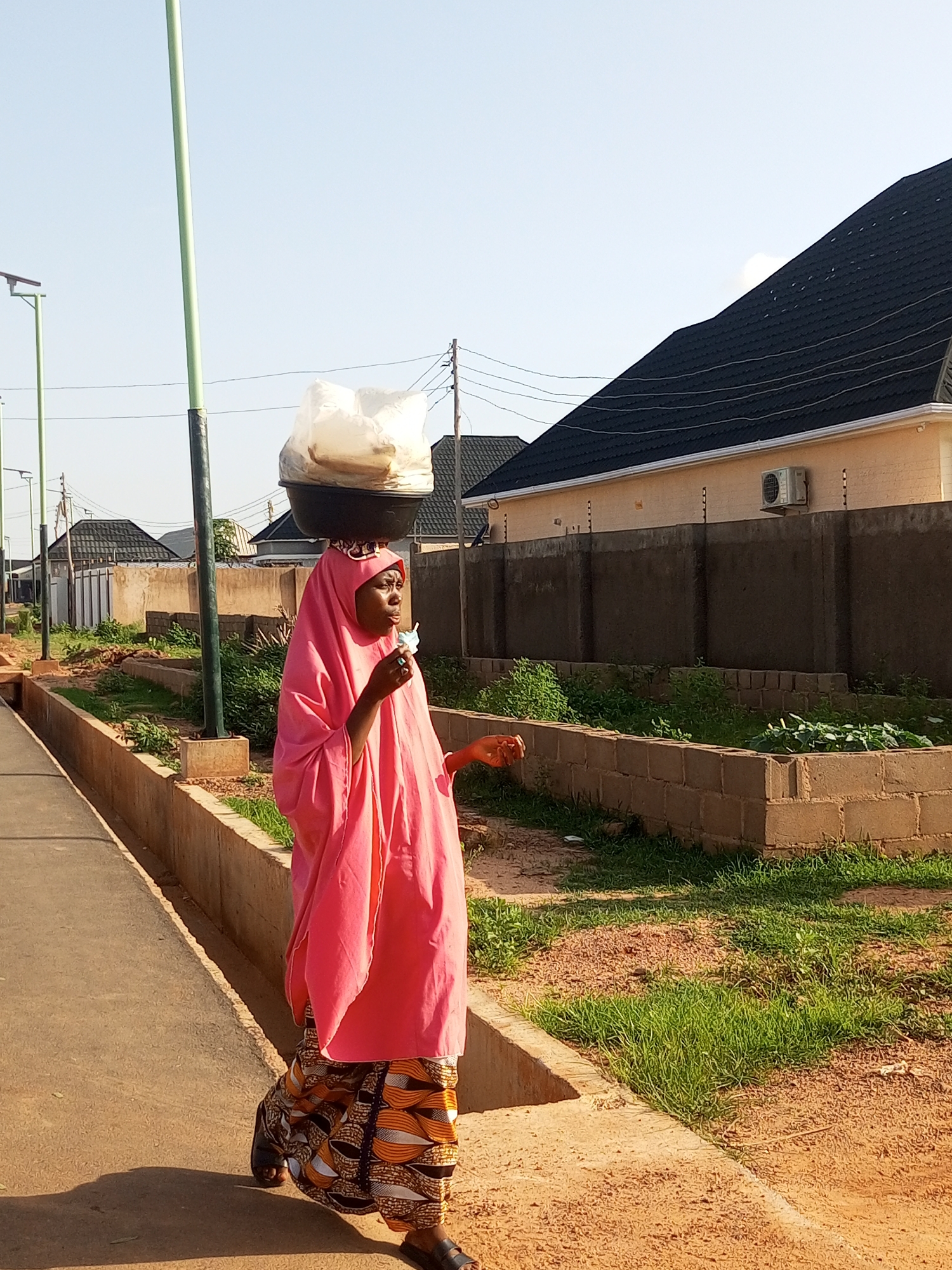 Everyday street life across two Nigerian towns, mid-afternoon.