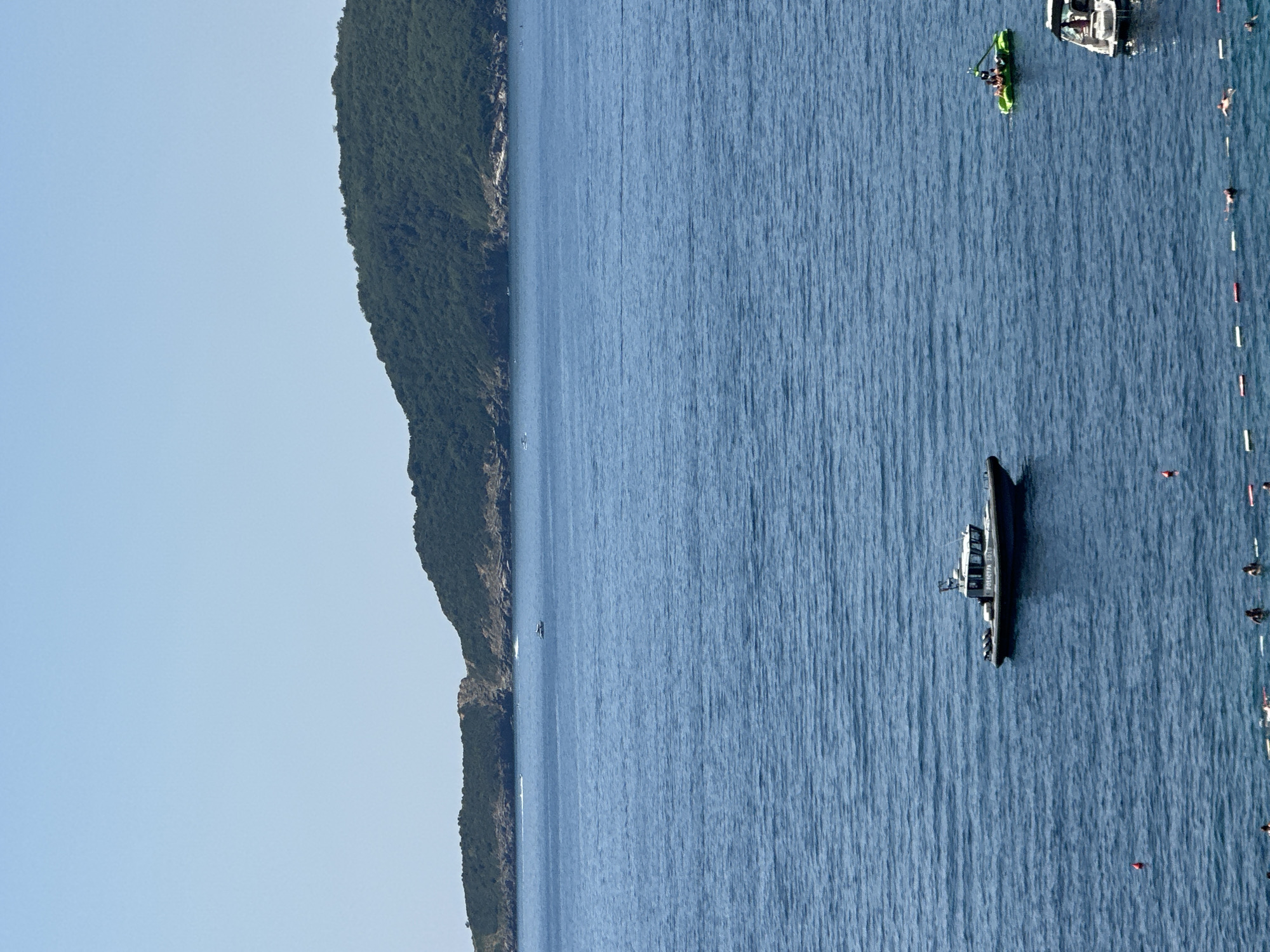 Crowded beach day at Kamenovo with parasailing over the Adriatic