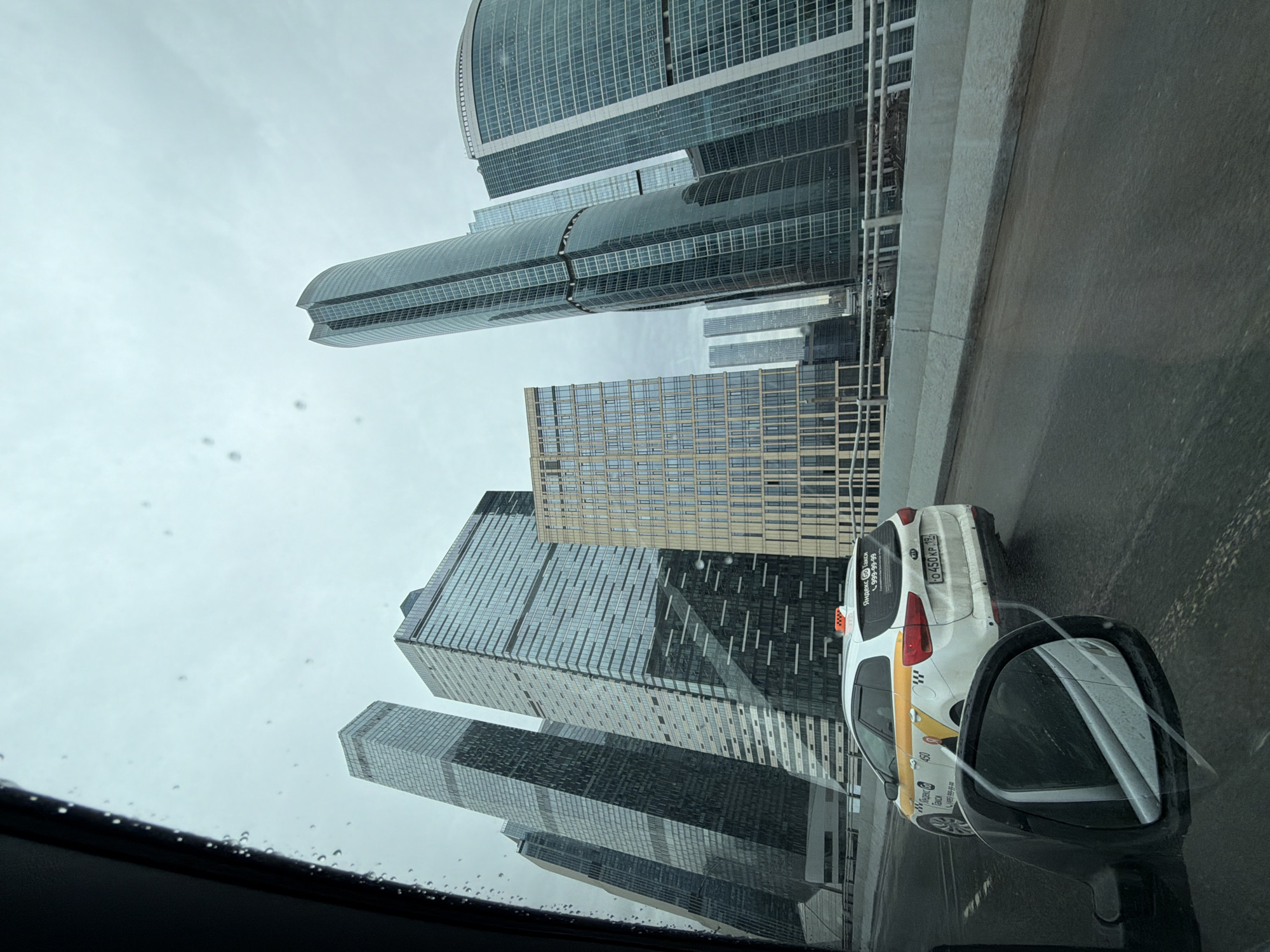 Rainy day view of Moscow City skyscrapers from vehicle