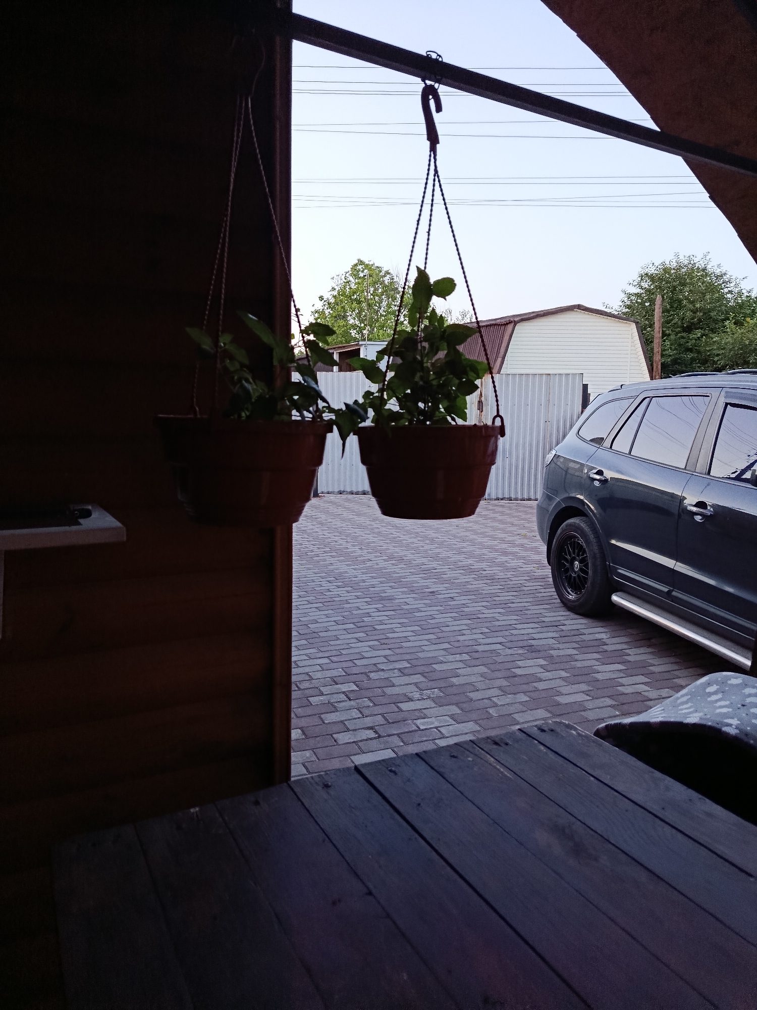 Hanging planters and greenery on a wooden outdoor patio