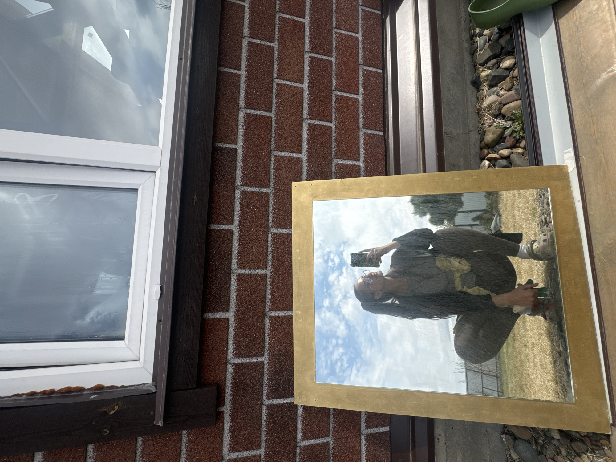 Person captures self-reflection while photographing gold-framed mirror in Russia