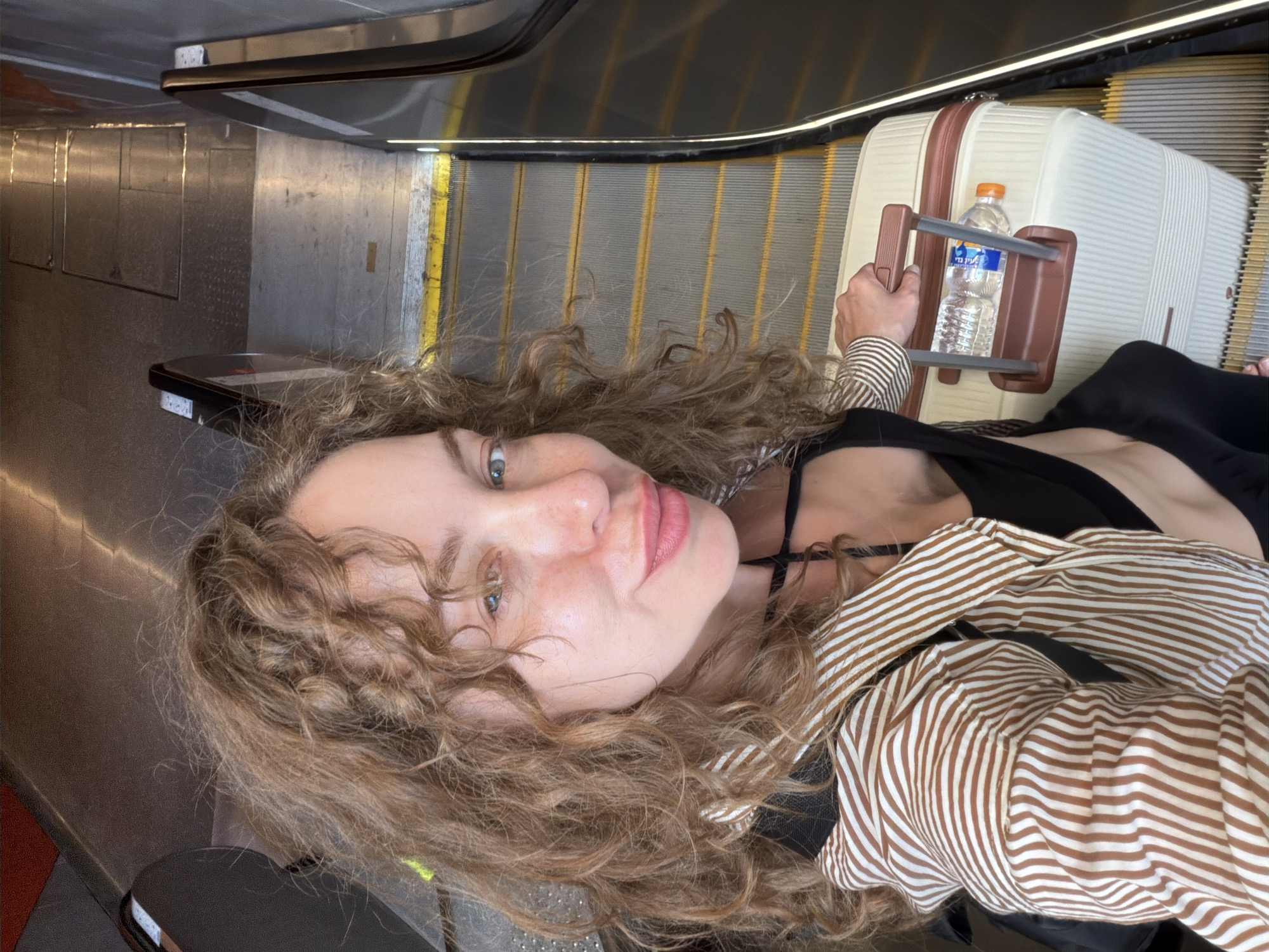 Selfie on escalator with luggage in Tel Aviv