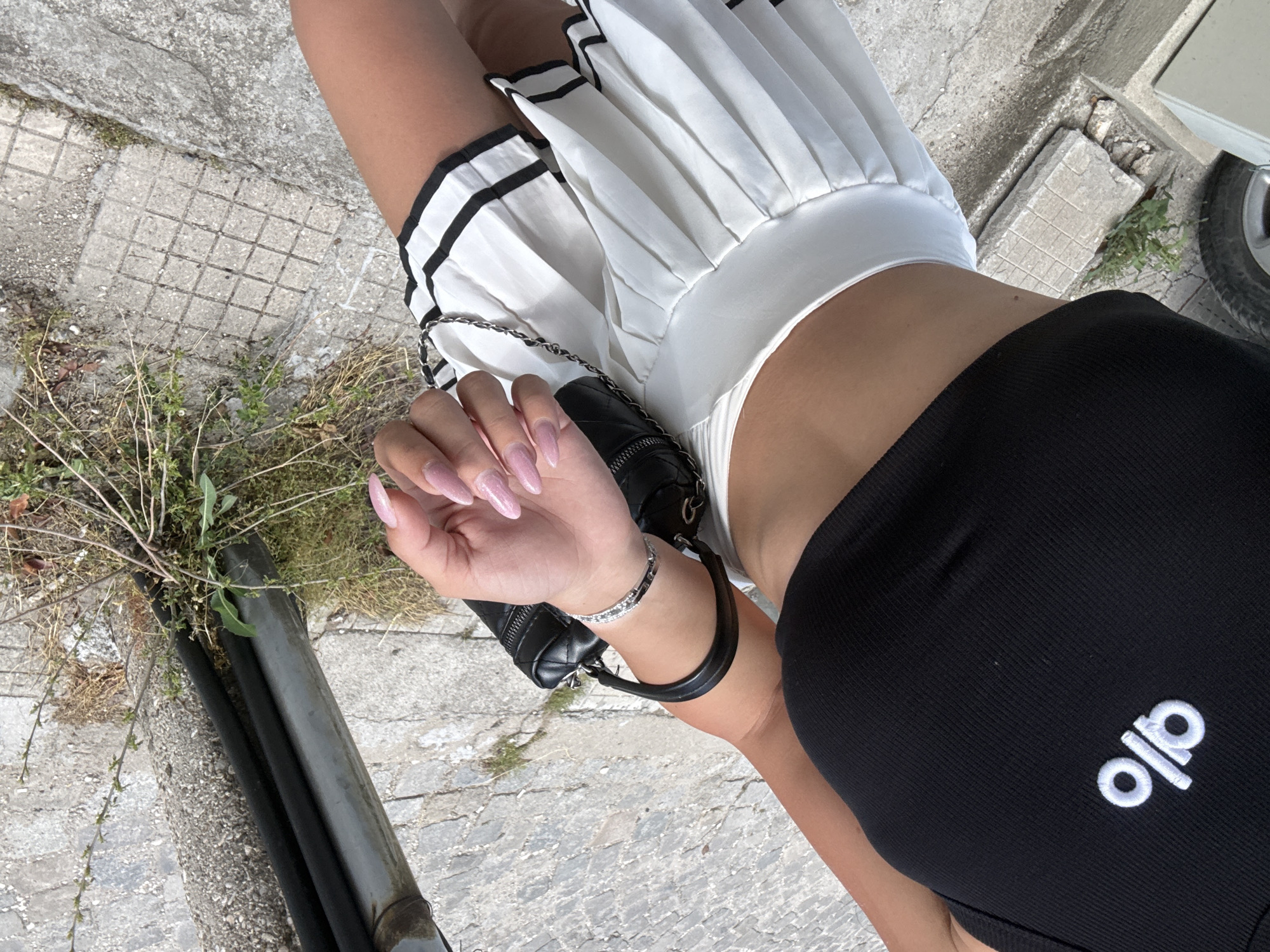 Woman in Alo outfit photographed taking selfies outdoors