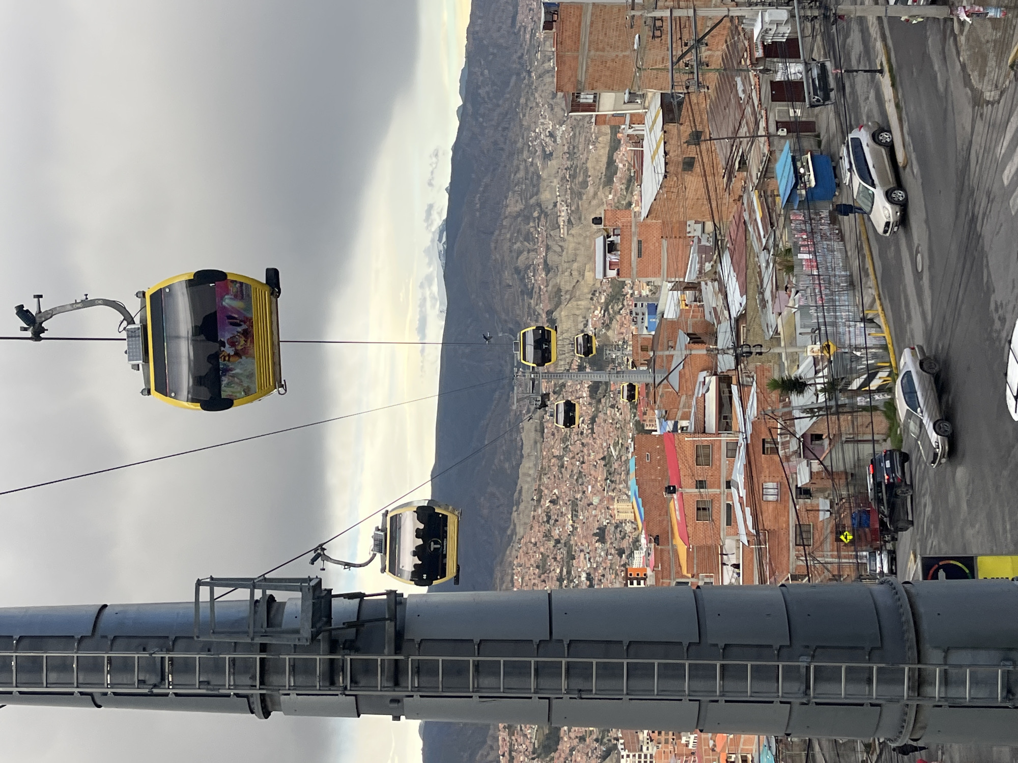 Cable car passengers observe La Paz cityscape from elevated stations