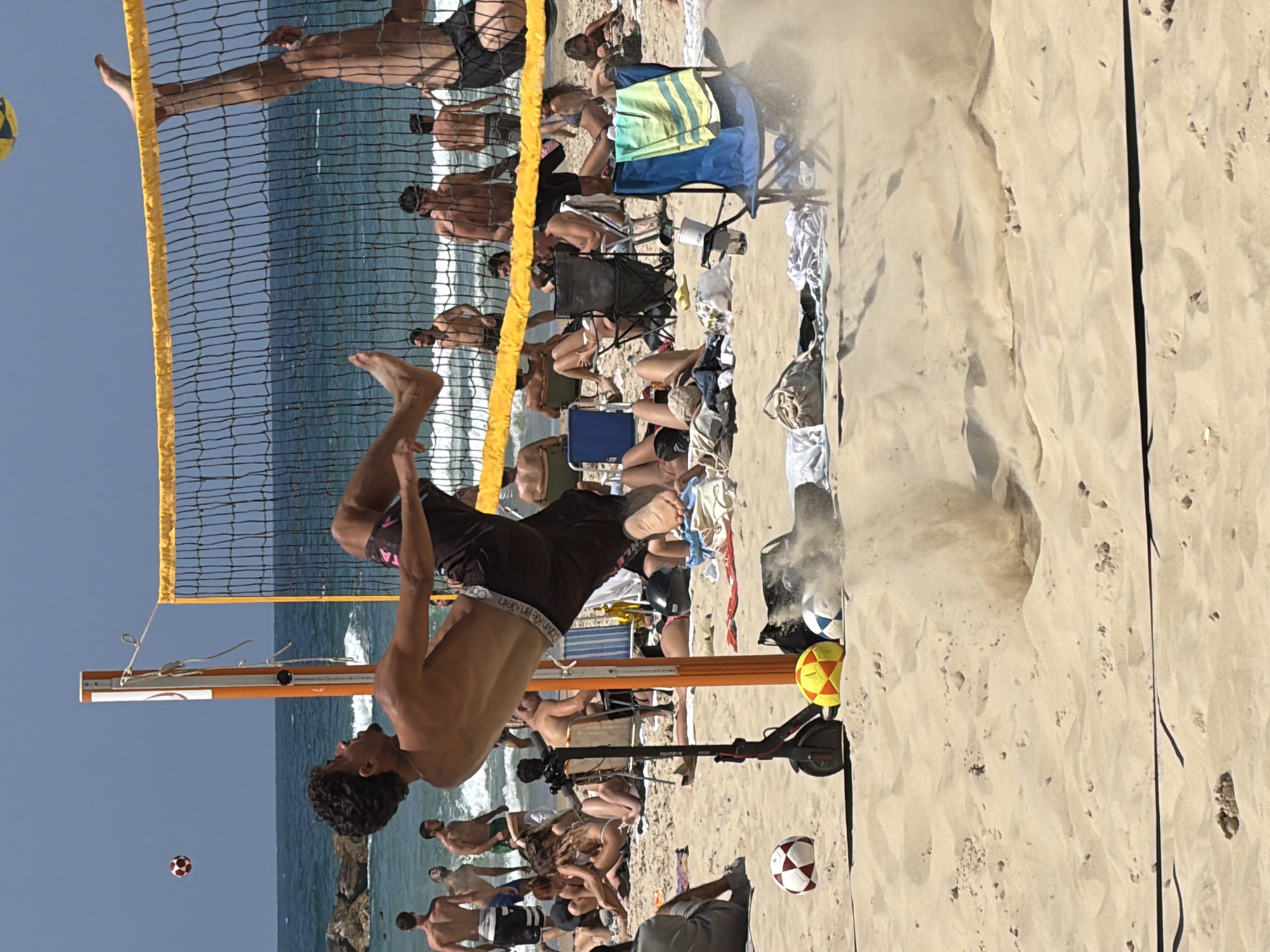 Sunny beach volleyball and sailing activity in Tel Aviv