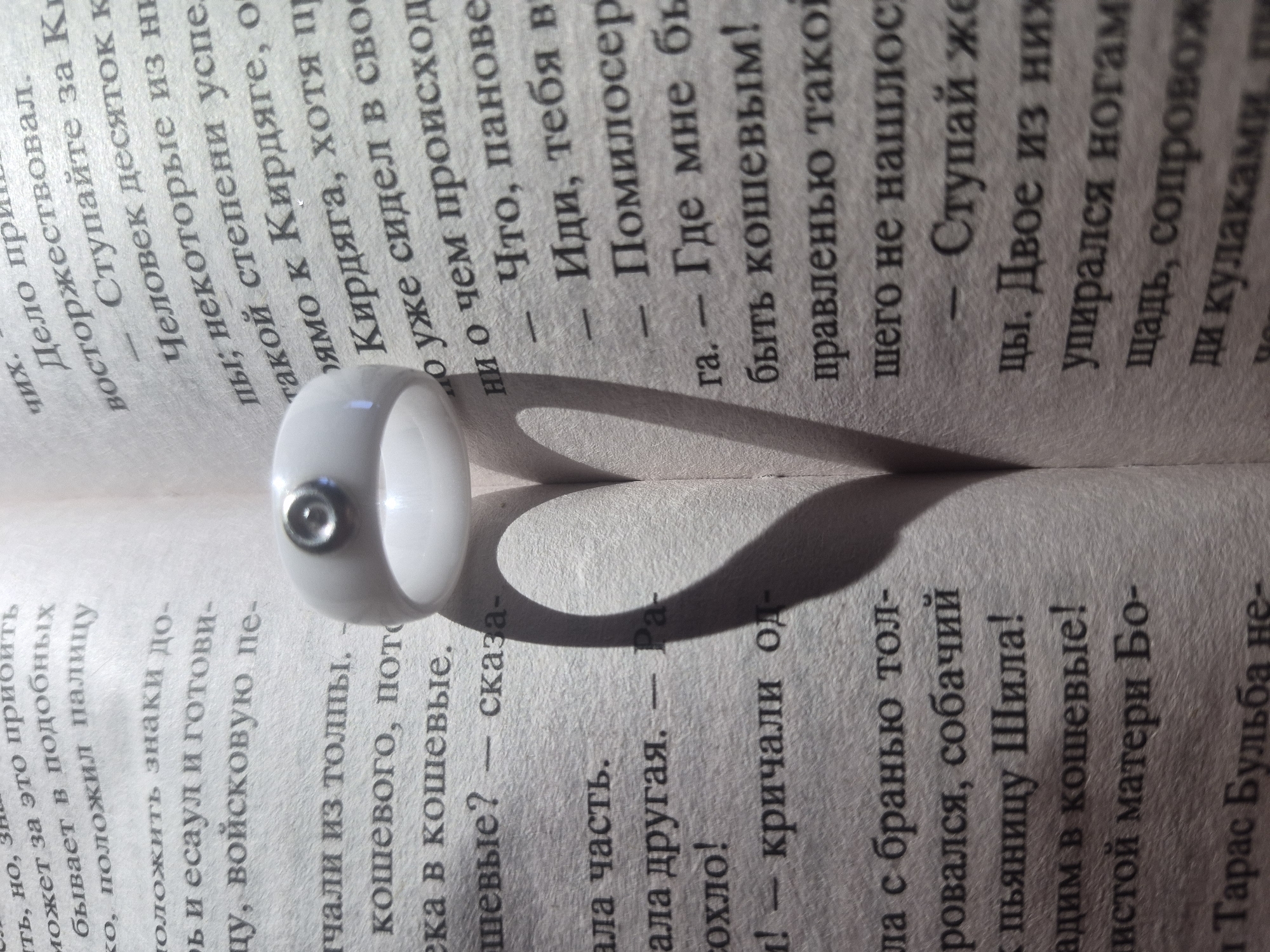 Ring casts heart-shaped shadow on Cyrillic text book
