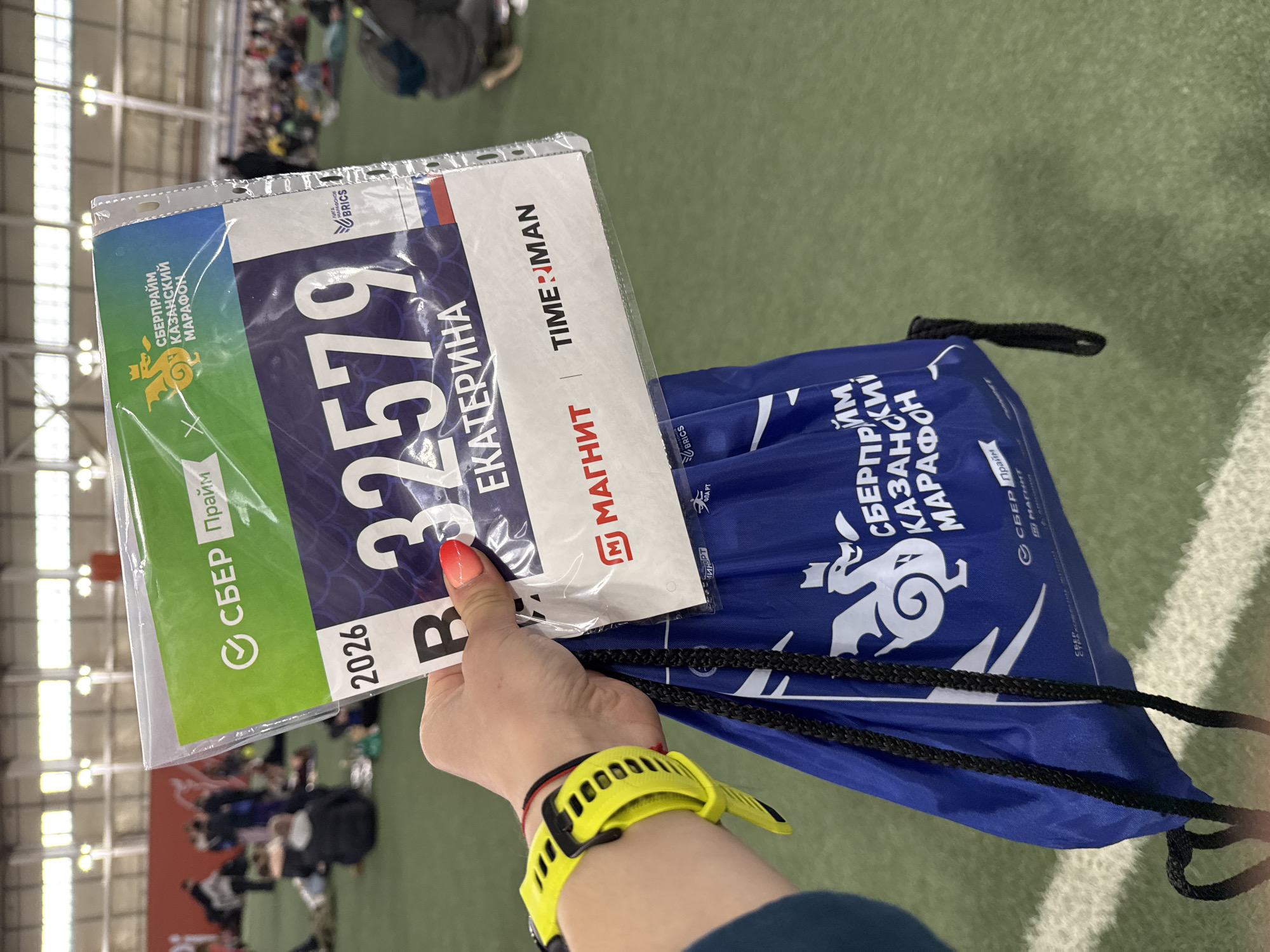 Runner holds race bib at indoor sporting event