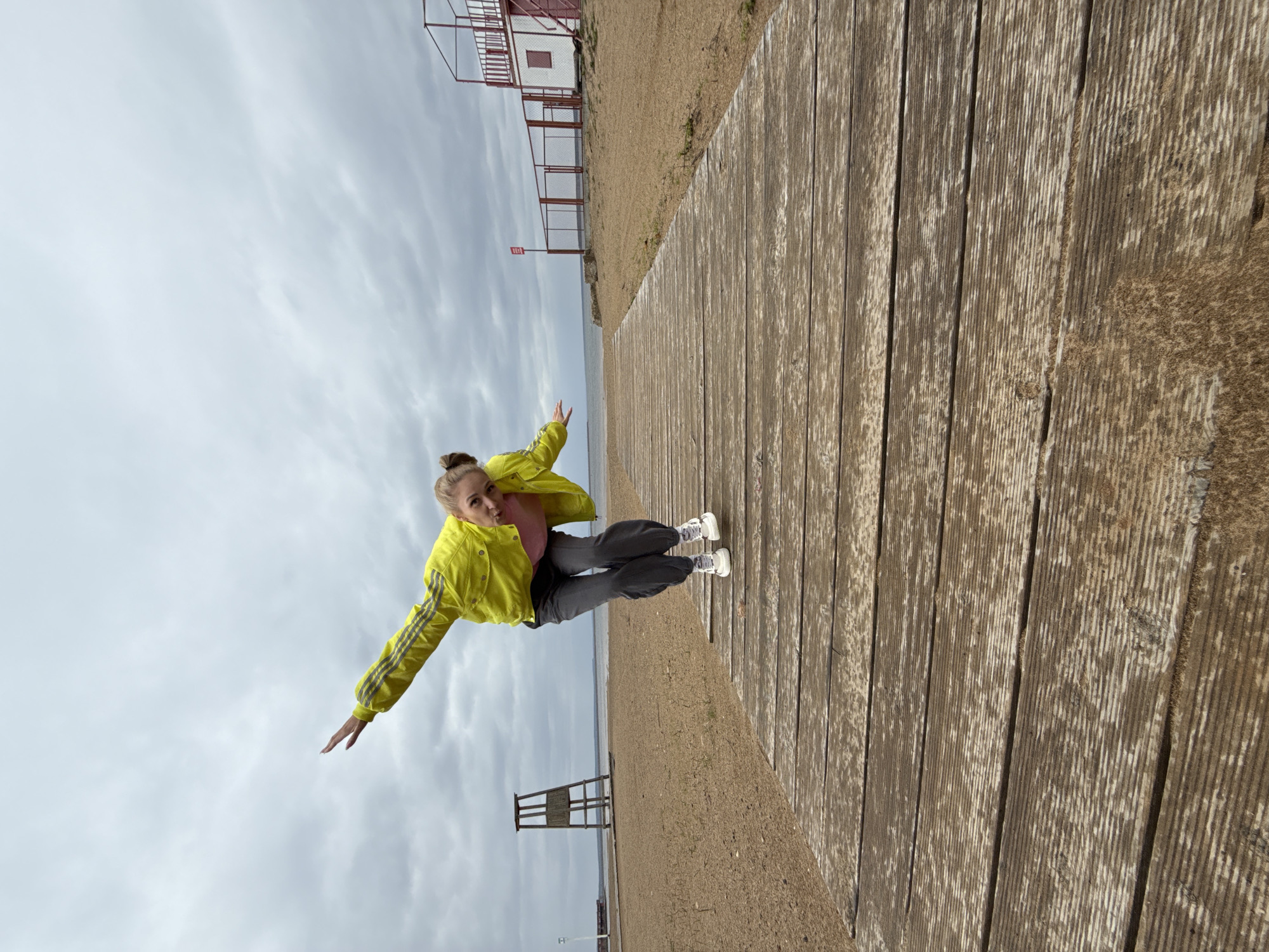 Woman poses playfully on boardwalk in Chaykovsky, Russia