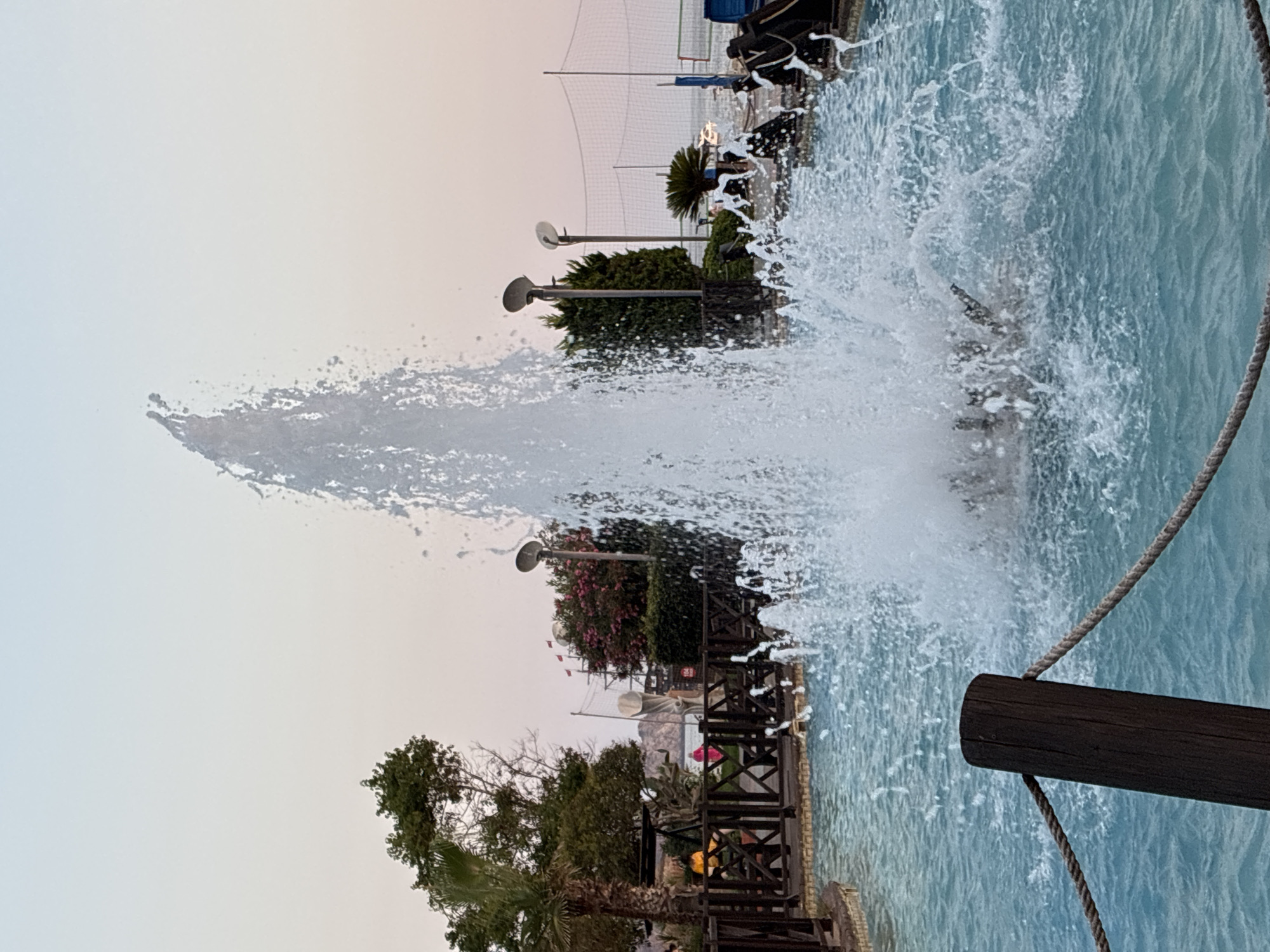 Alanya waterfront at dusk: fountains, beach, and a resting cat