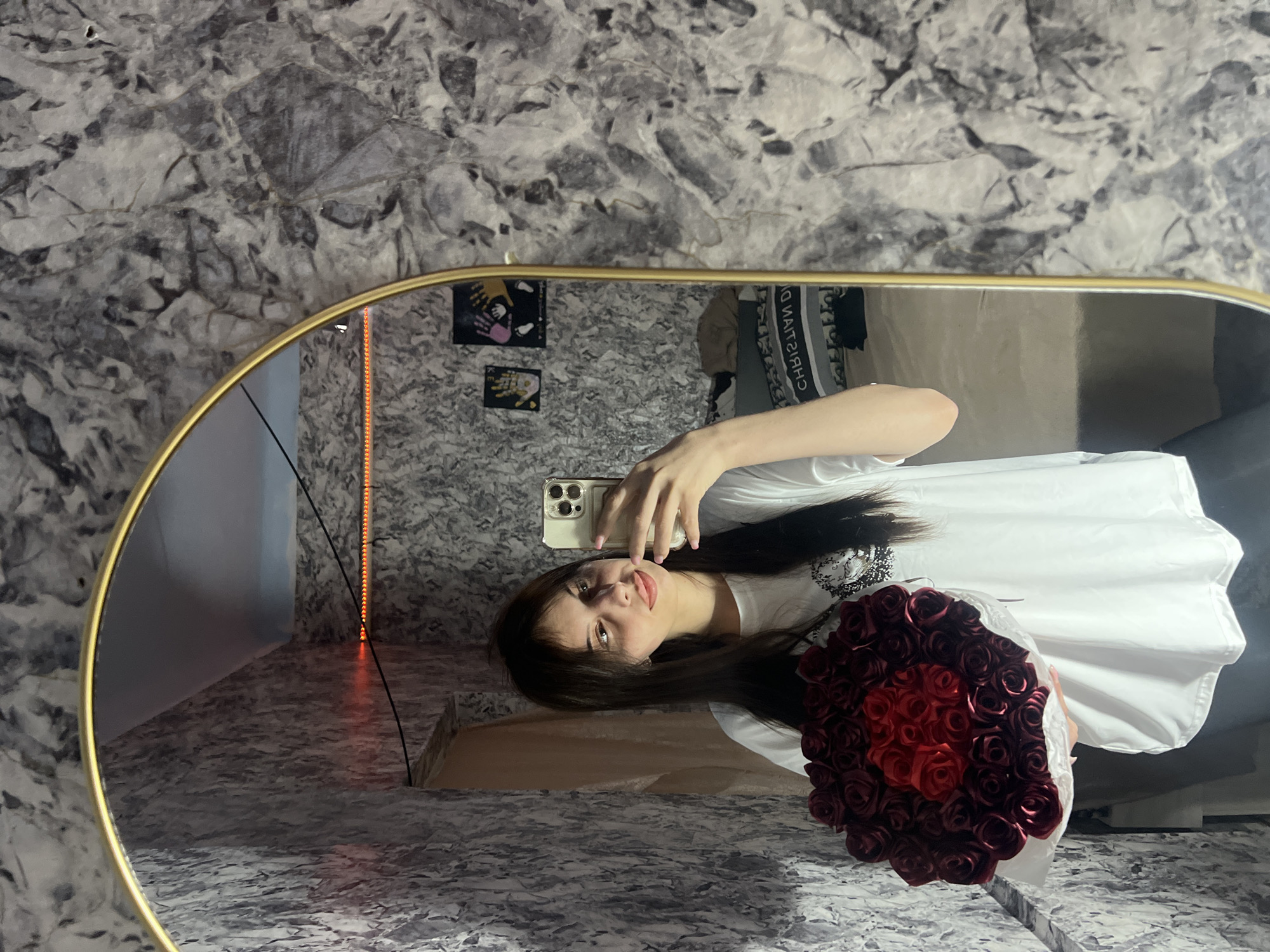Woman takes mirror selfie with red roses in Moldova