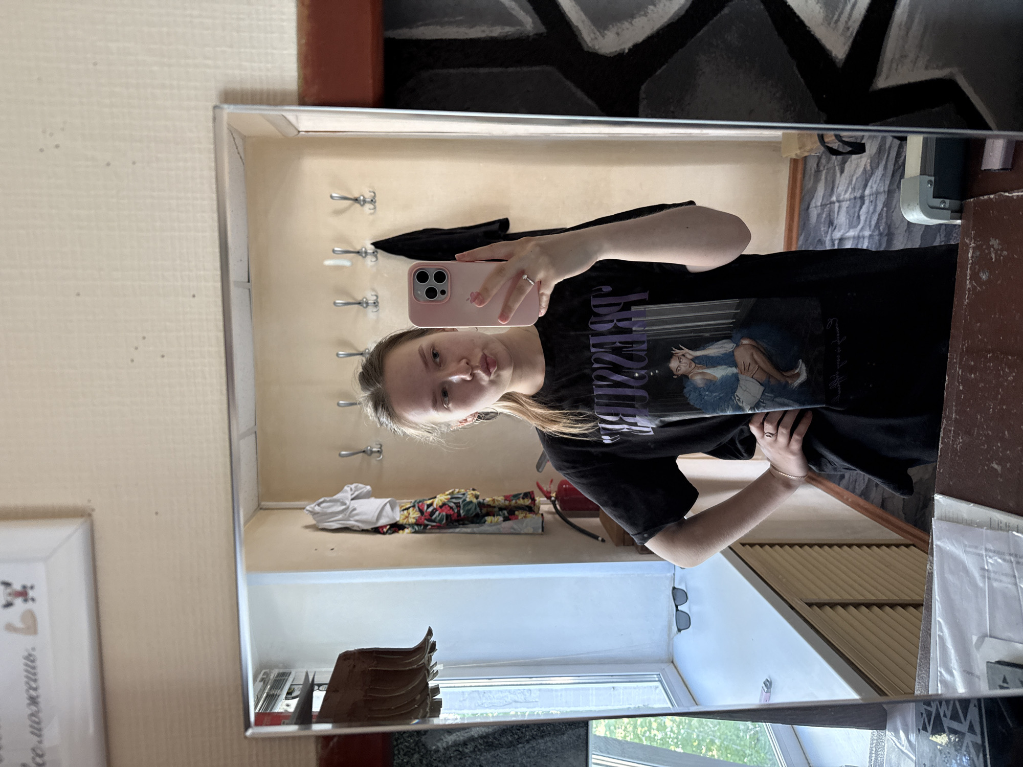 Woman takes mirror selfie with pink phone in Chaikovsky