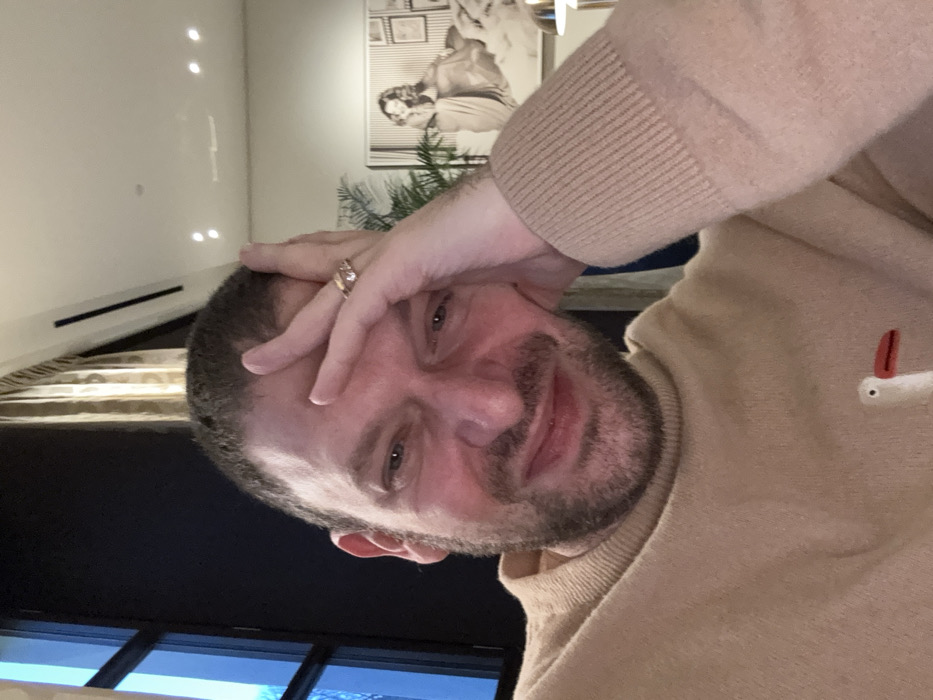 Man in brown sweater observed indoors in Milan