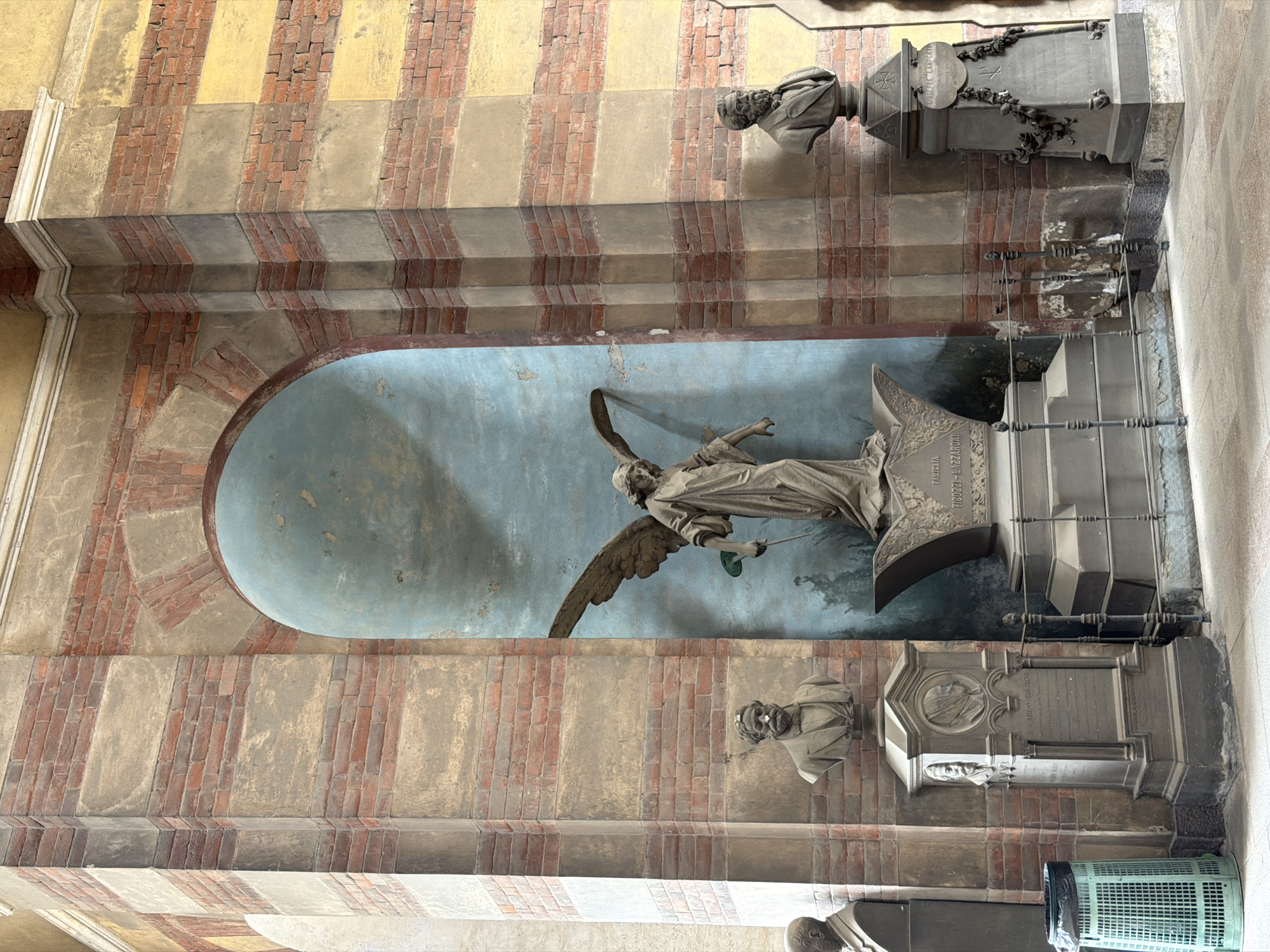 Visitor documents ornate architecture at Milan's Monumental Cemetery