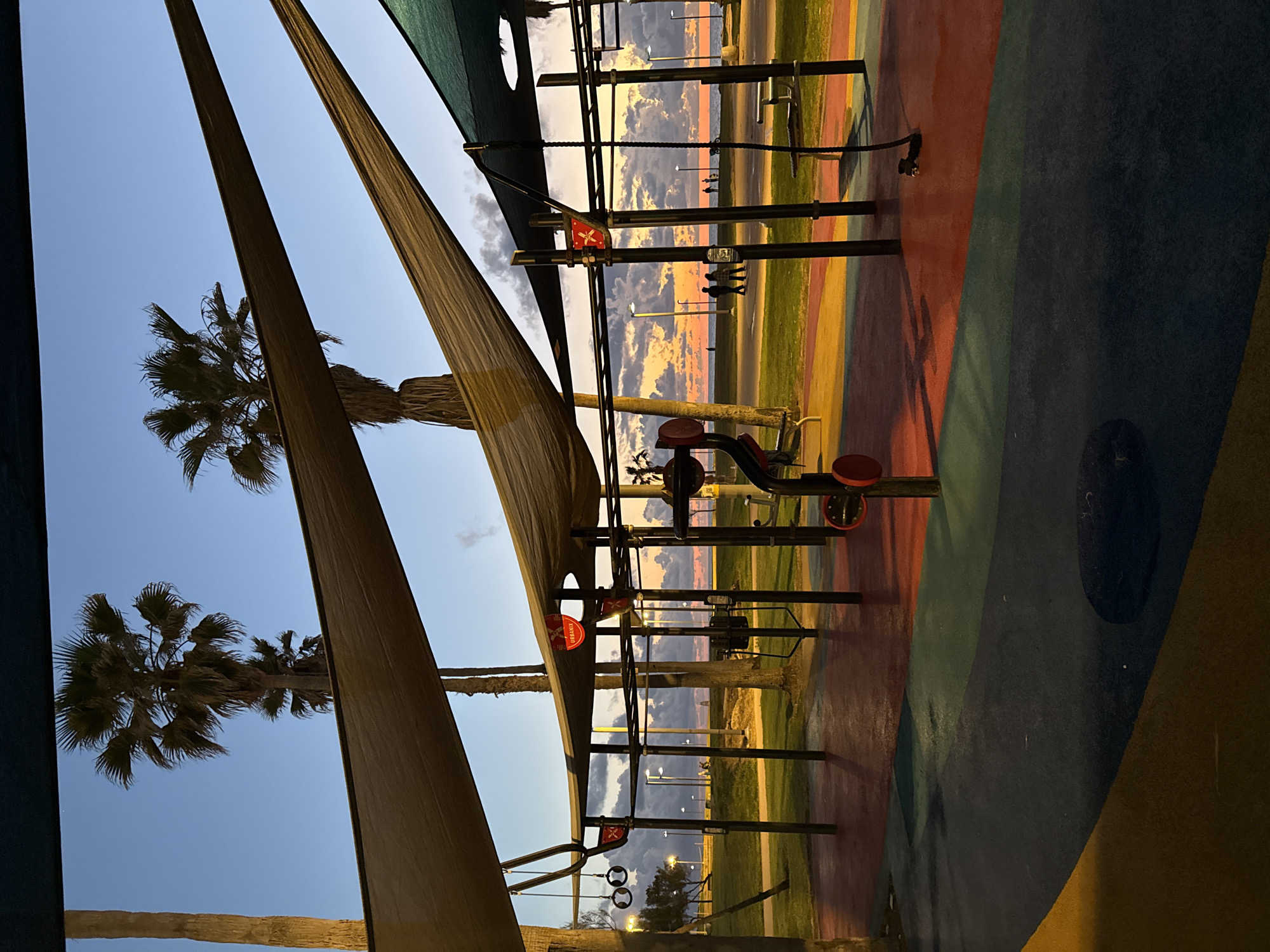 Three people gather on Tel Aviv beach at sunset