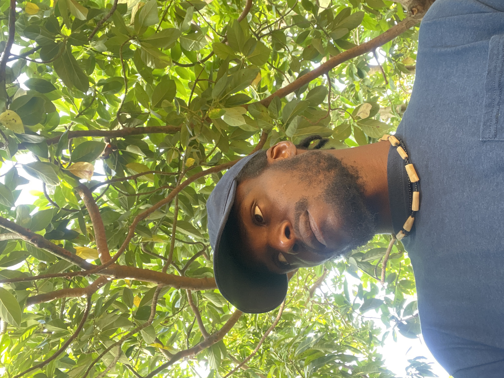 Man photographed in portrait session under trees in Jos