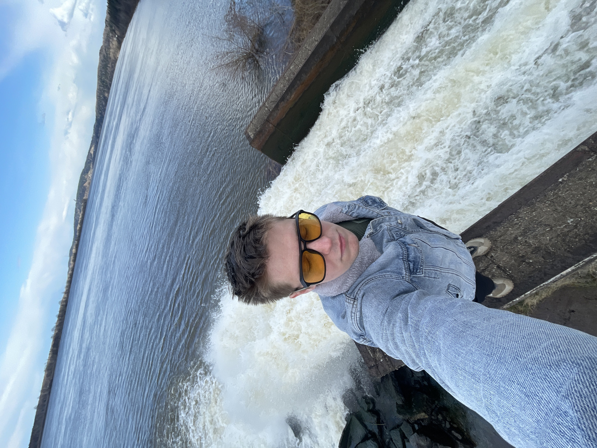 Young person takes selfie at waterfall edge