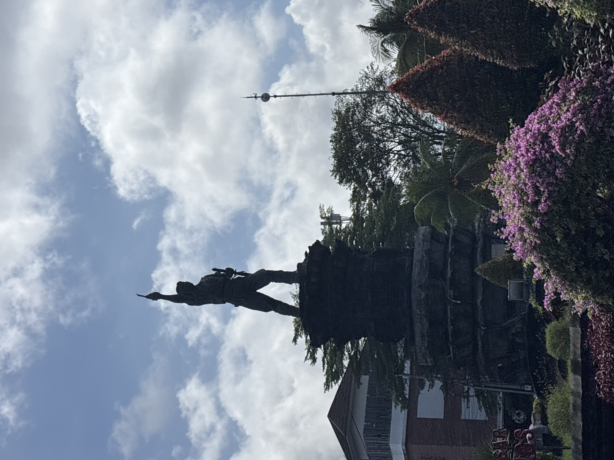 Monument with pointing figure observed in Denpasar park setting
