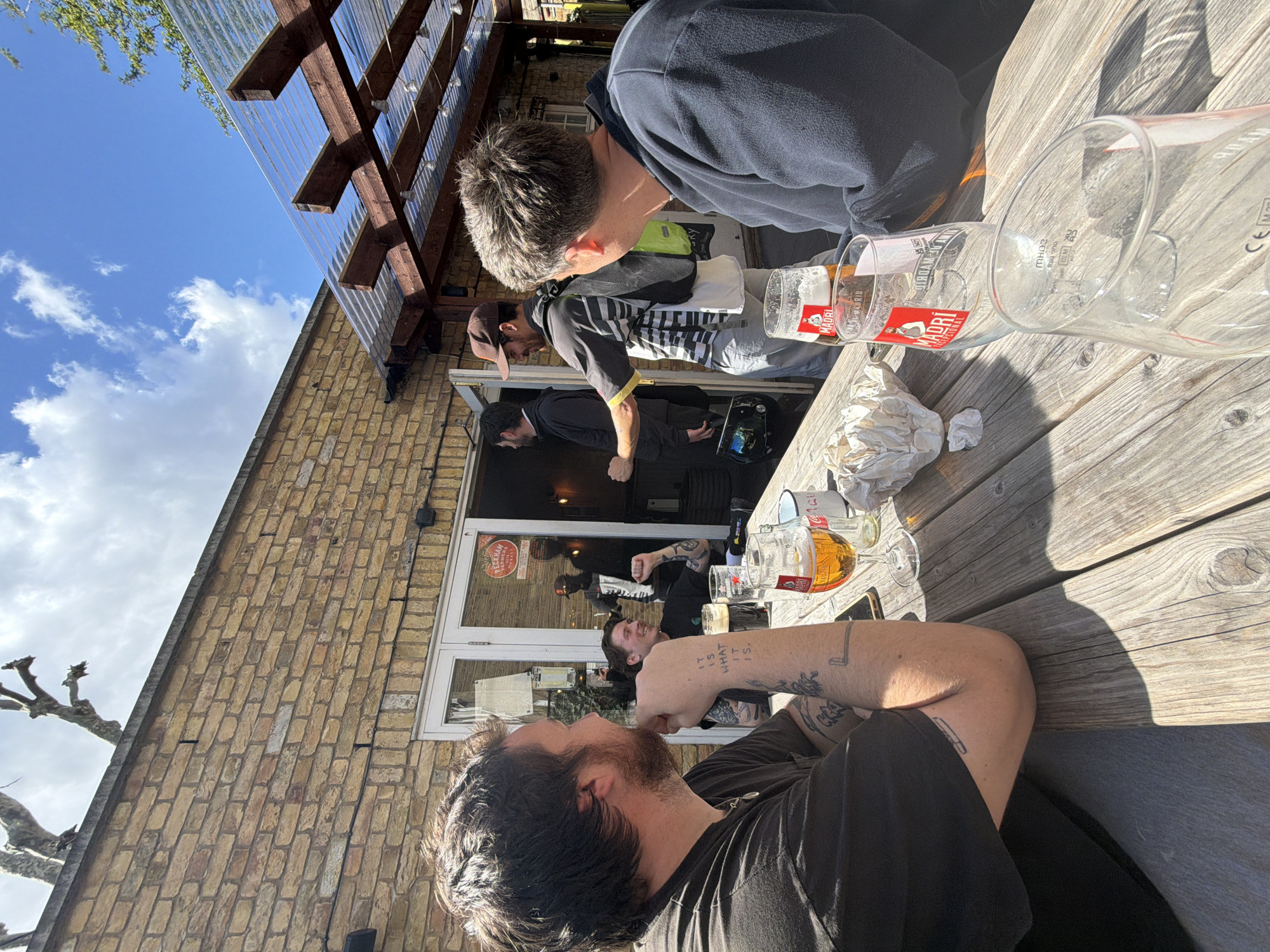 Three men gather at London pub outdoor seating area