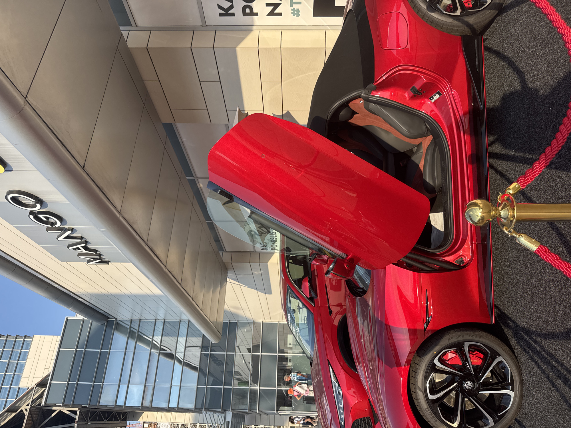 Red MG Cyberster on display near urban commercial district