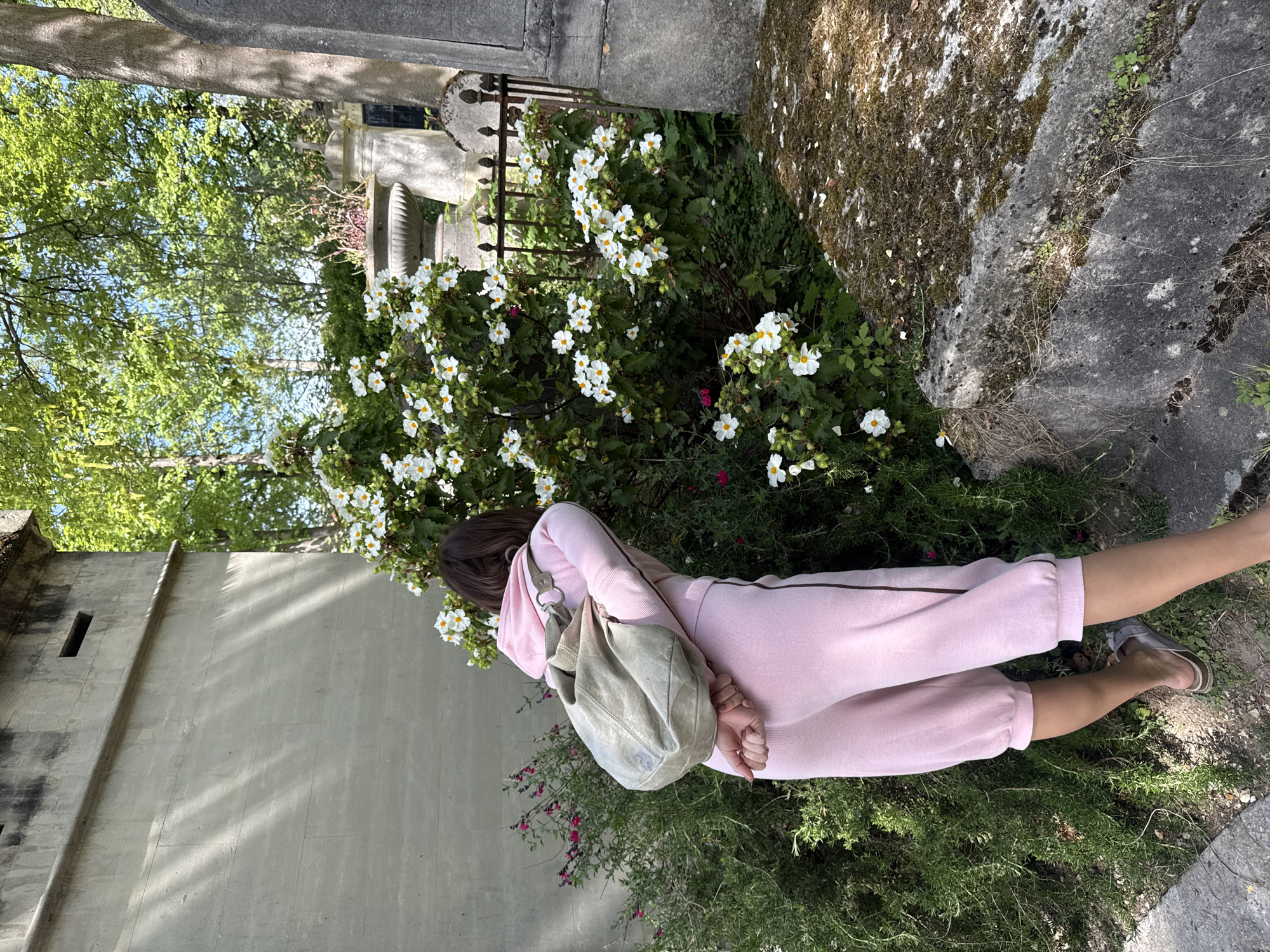 Woman in pink sweatsuit lies in Paris garden