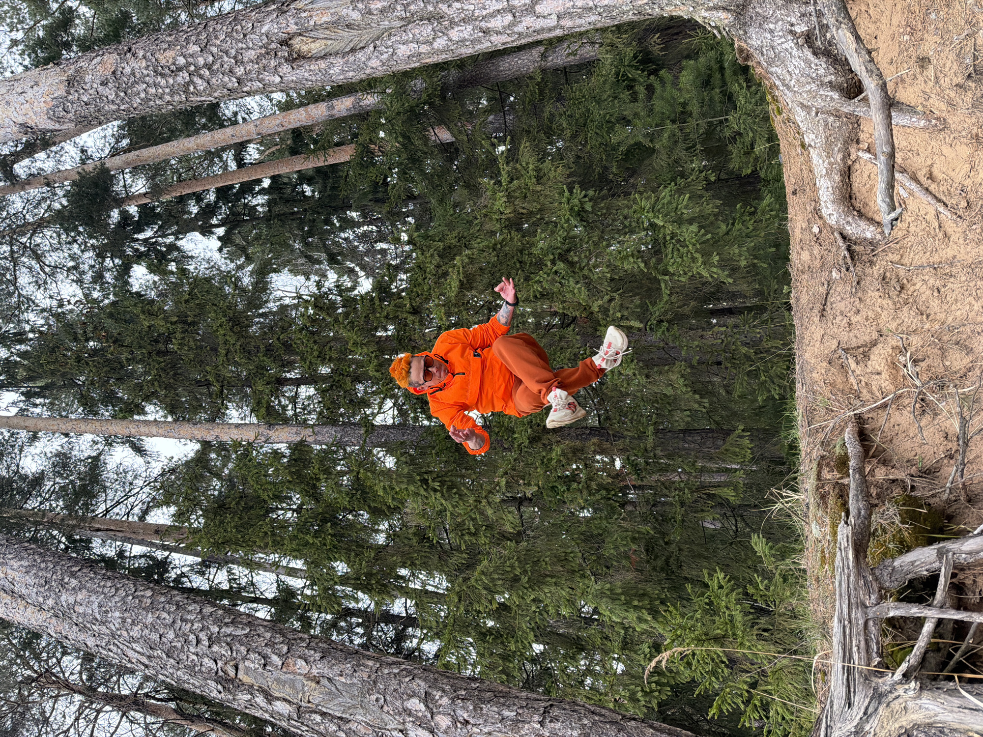 Person in orange performs acrobatics in Russian forest