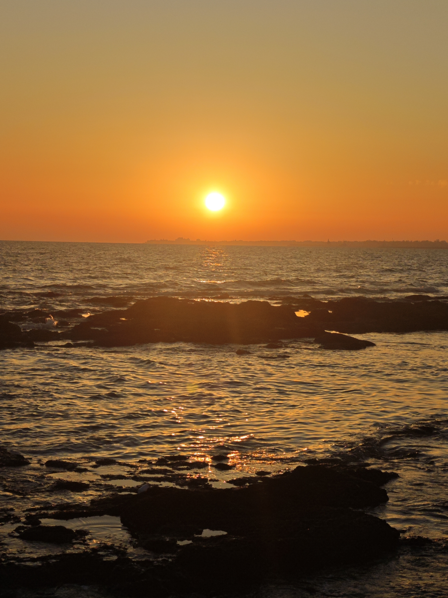 Atlantic sunset fades from white to red off Costa Oeste