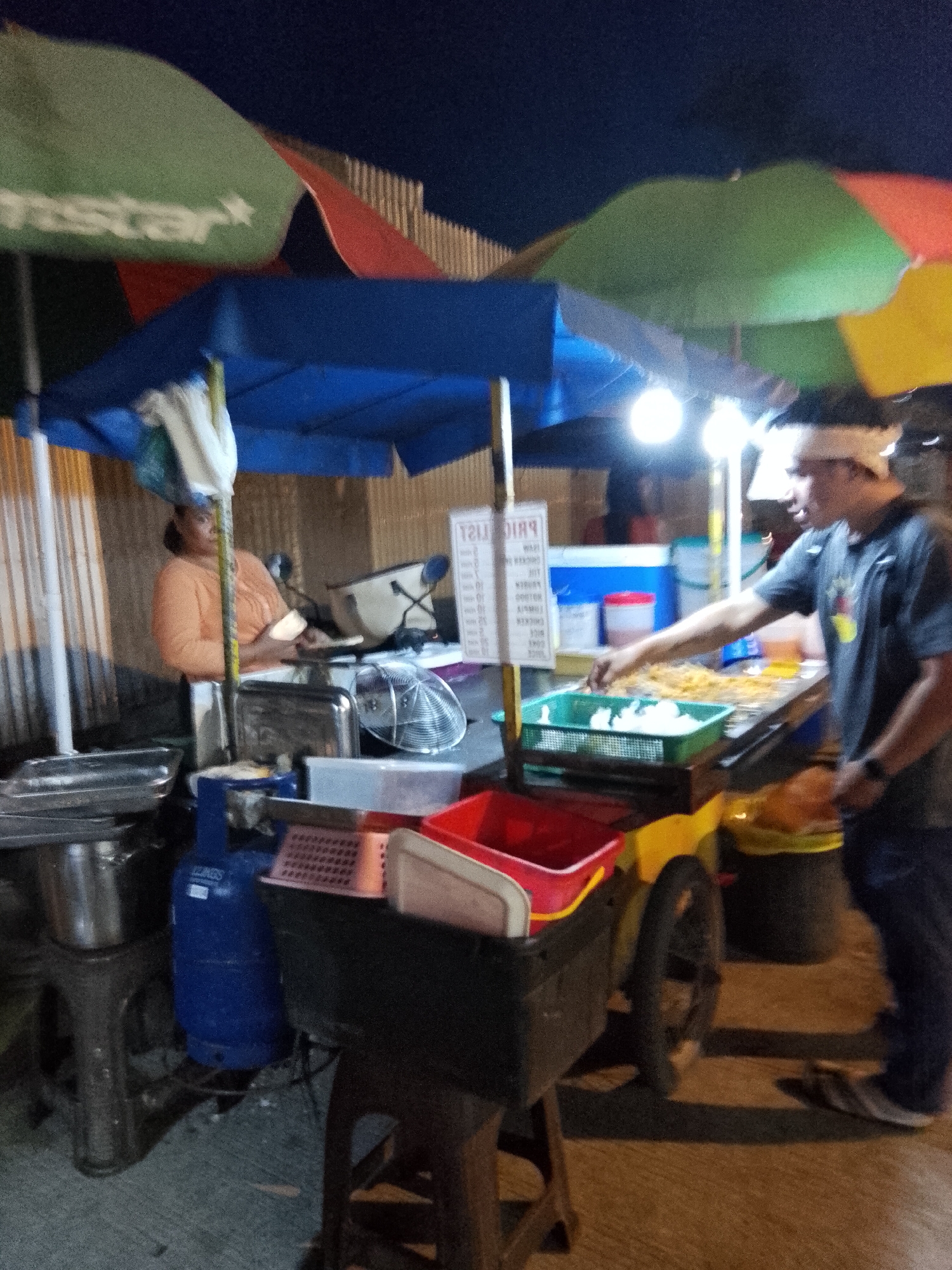 Davao City streets at dusk: traffic, food stalls, and neon glow