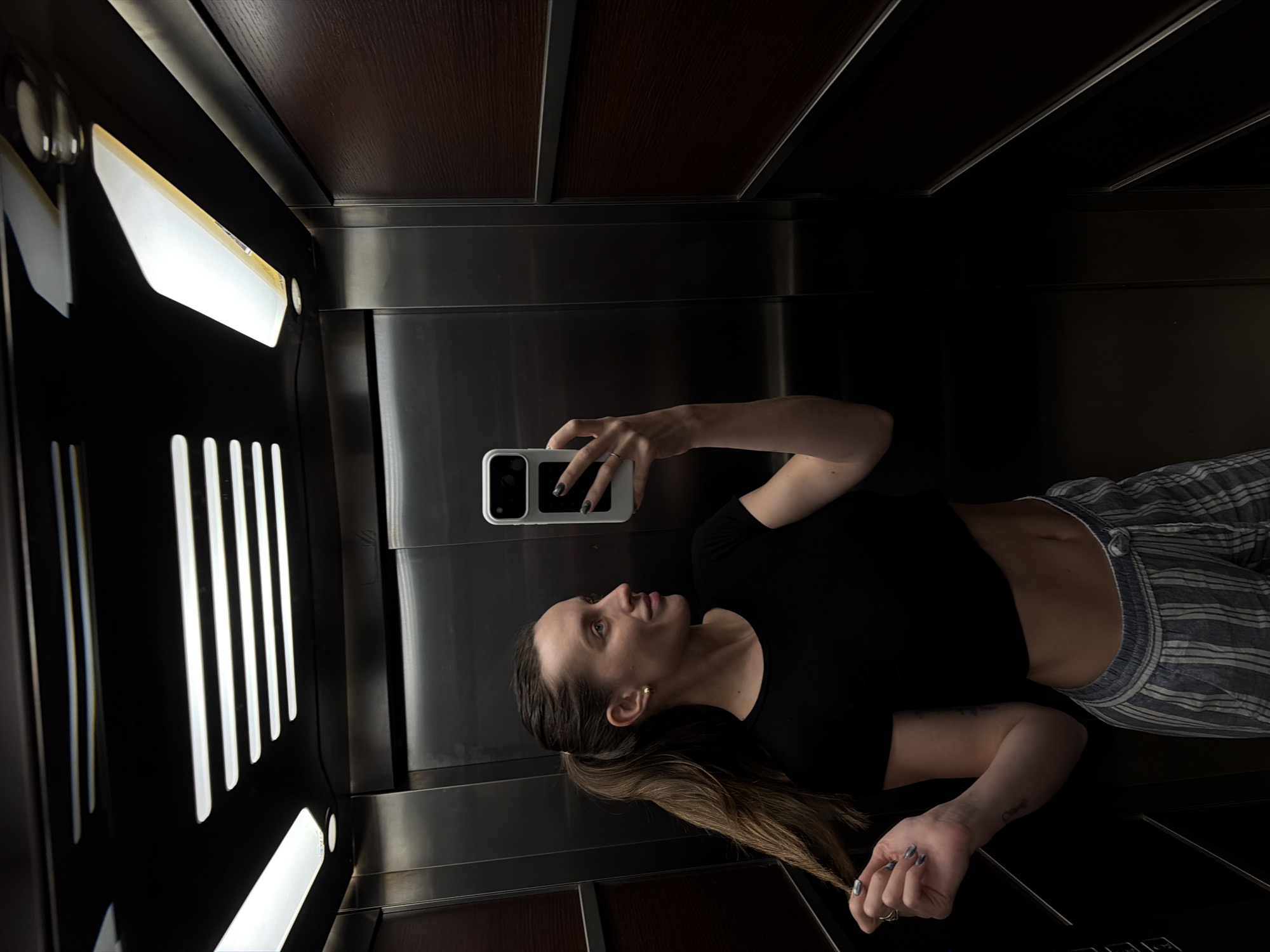 Woman takes rotated mirror selfie in Budva elevator