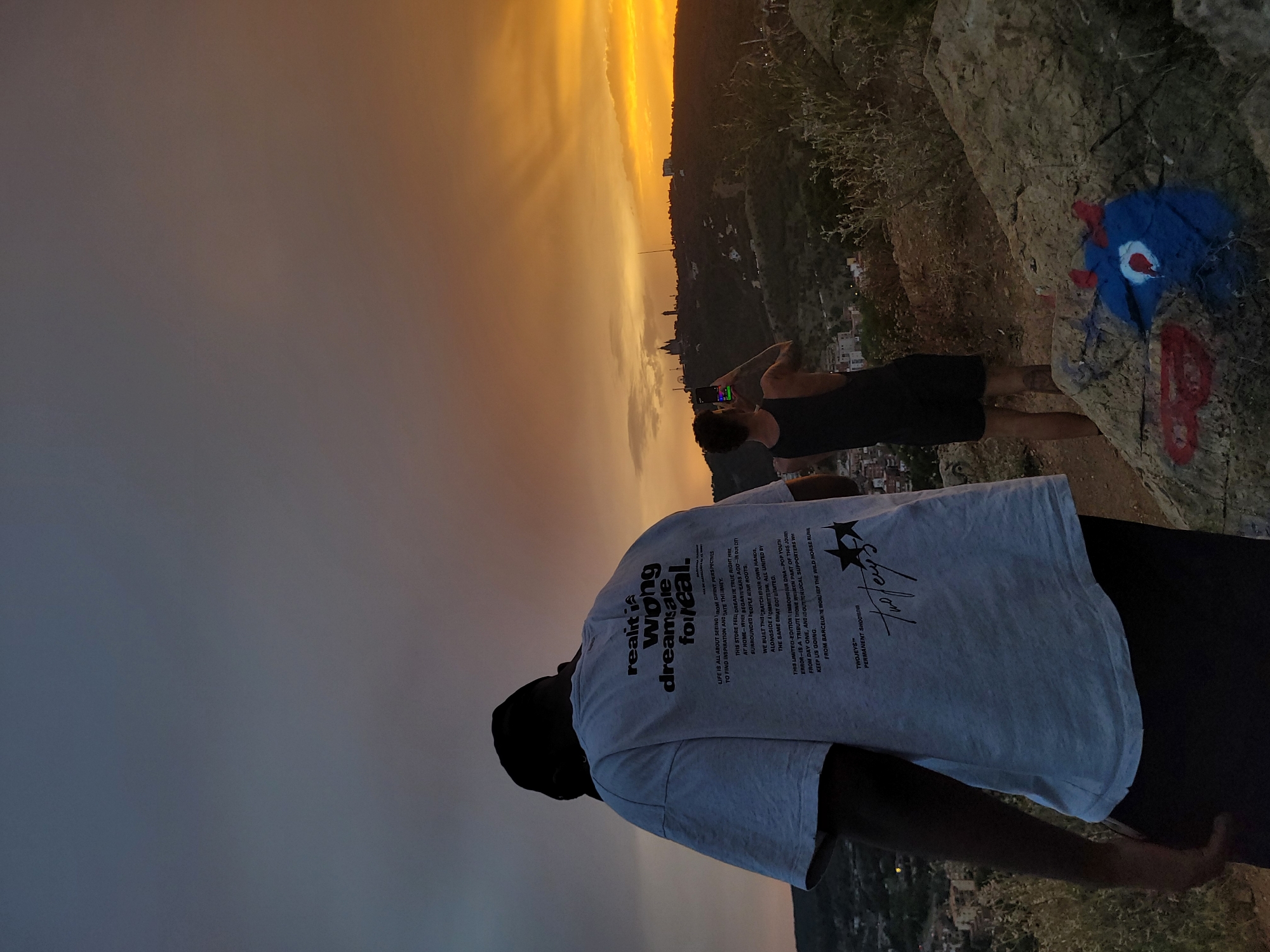 Sunset photographers gather at city overlook cliff