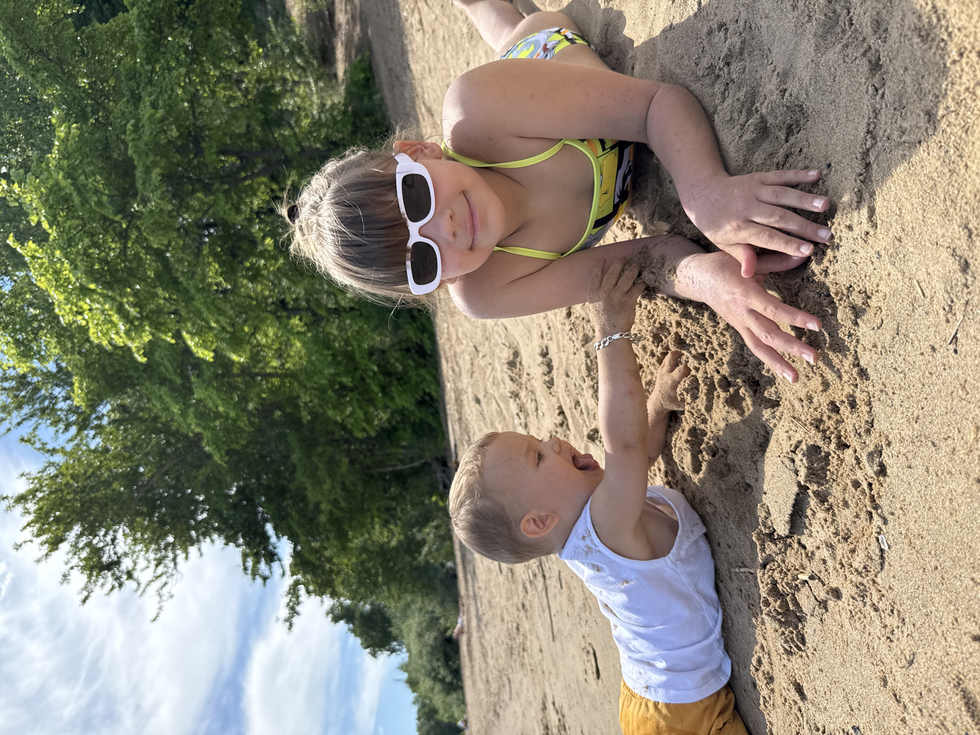 Children play on sandy beach in Rusanovo, Russia