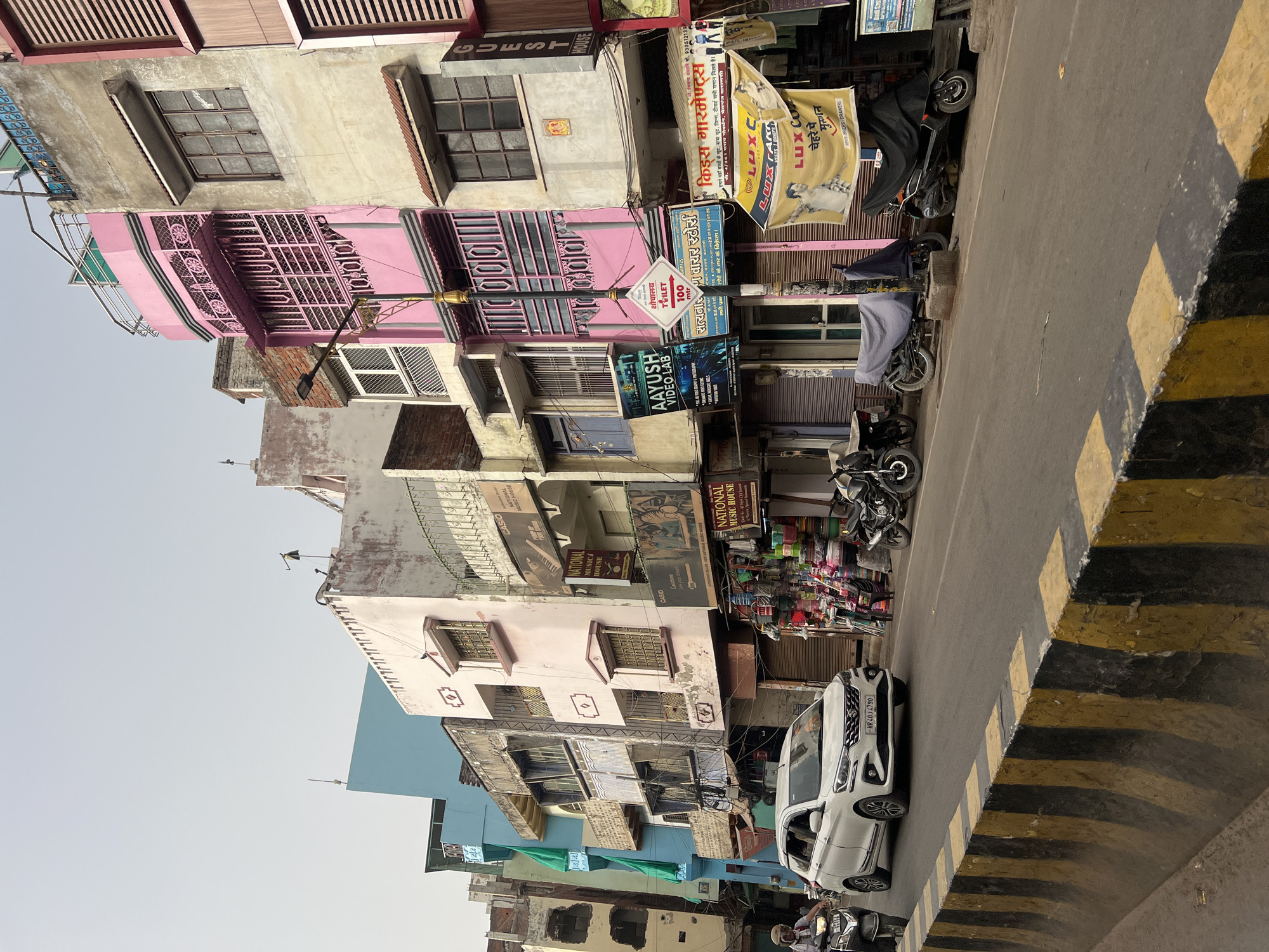 Man tends small street fire in Varanasi commercial district