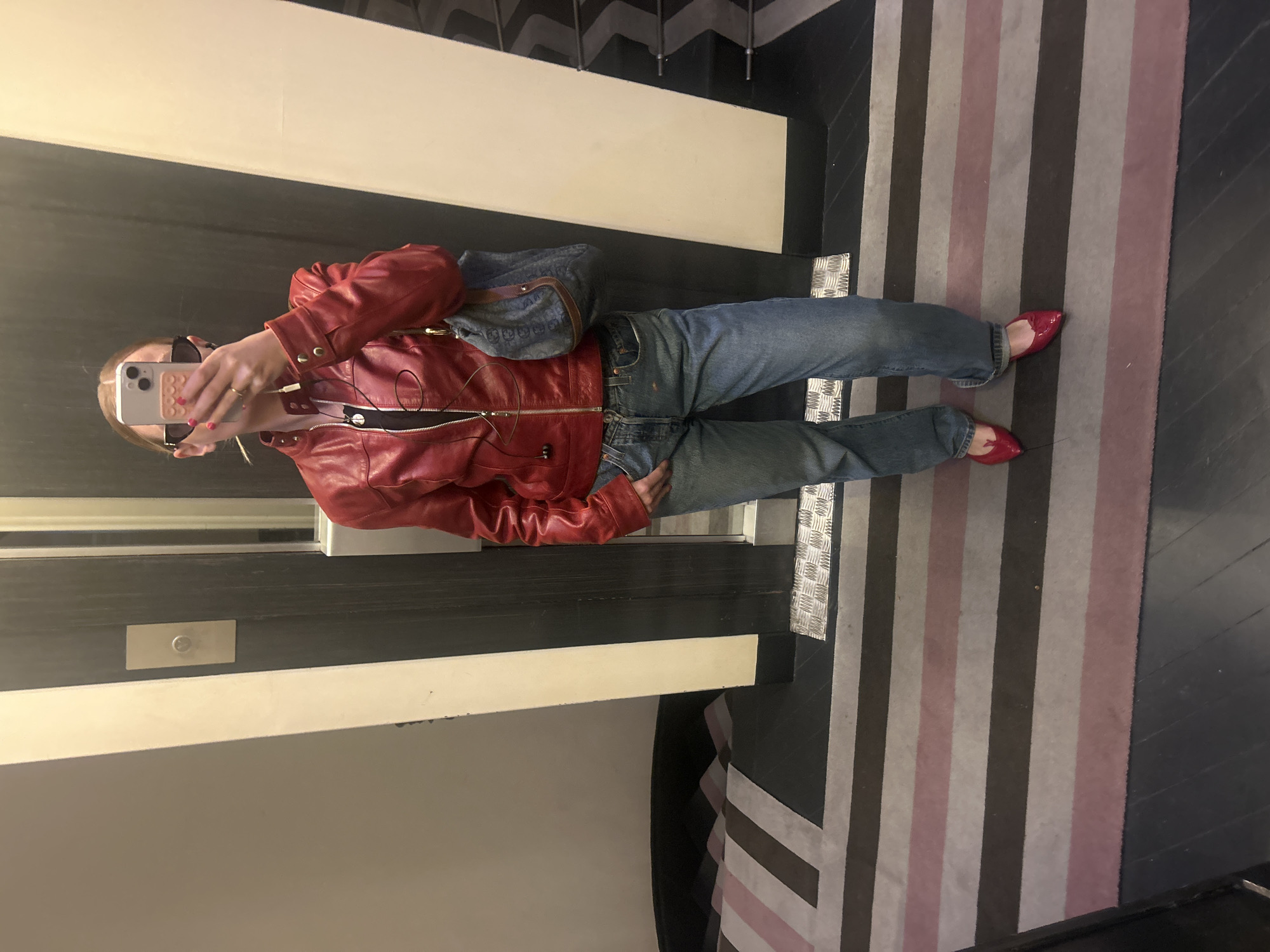 Mirror selfie taken with red jacket and pink-cased iPhone