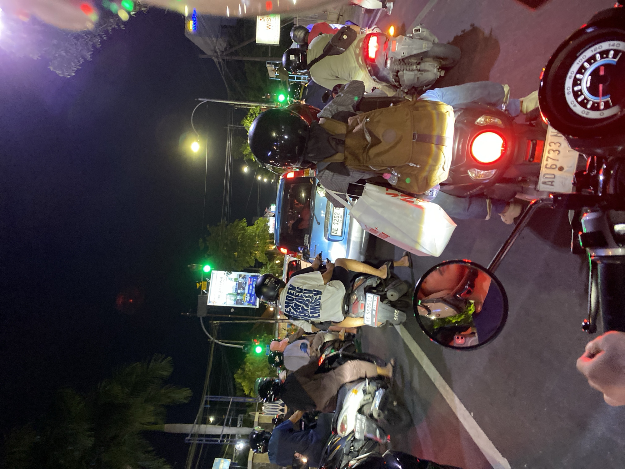 Motorcyclist documents nighttime traffic scene in Madiun, Indonesia