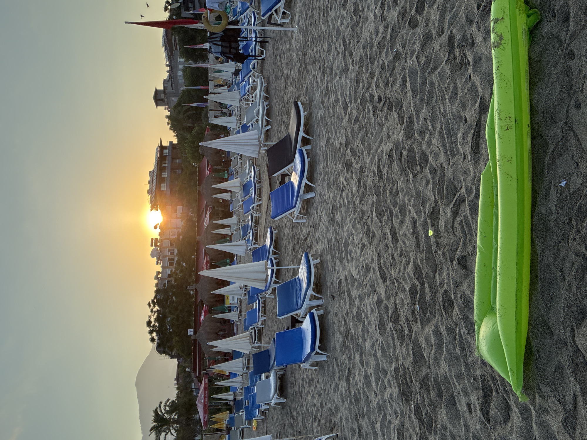 Alanya beach at sunrise, pigeons, a cat, and calm sea.