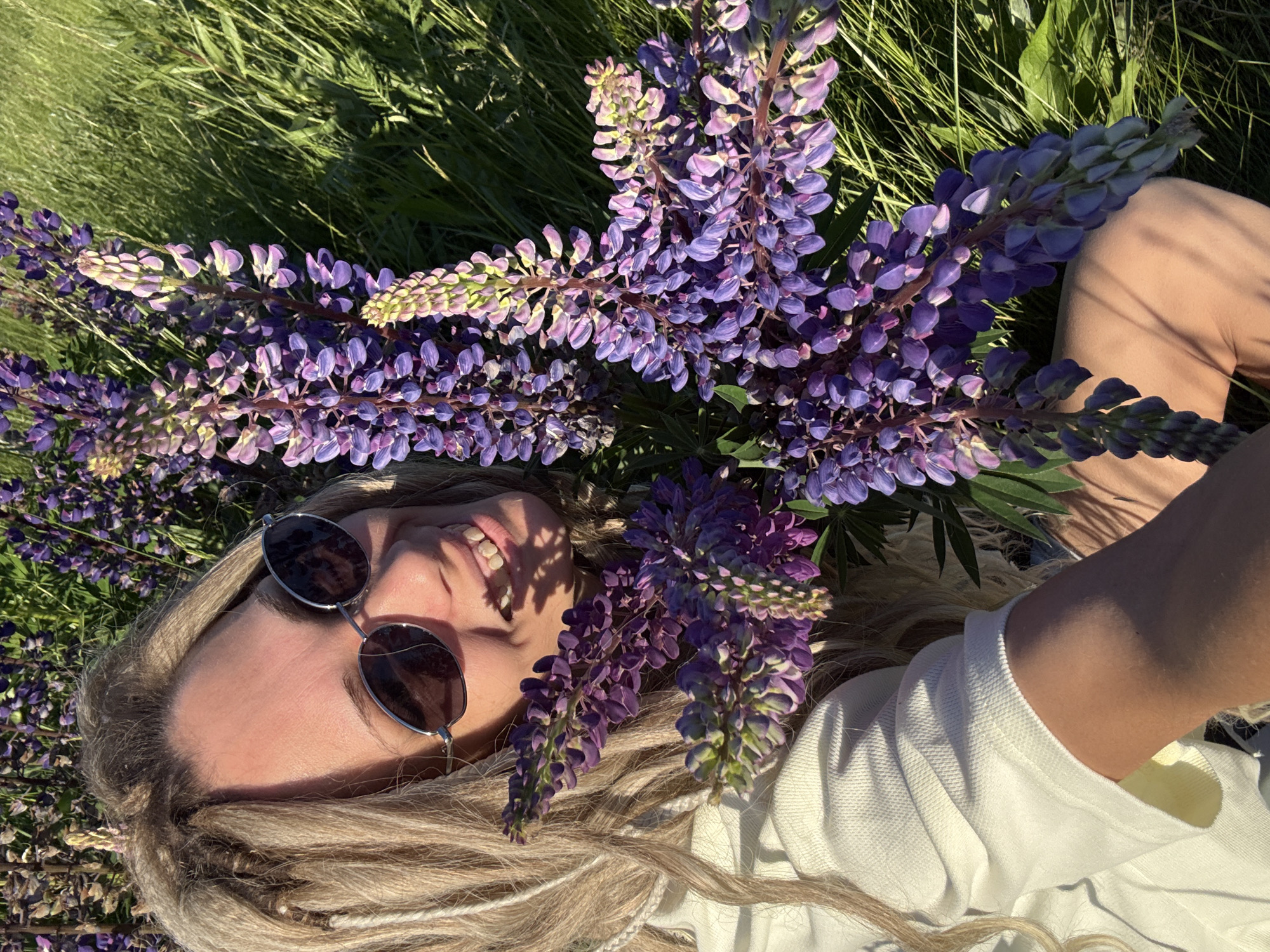 Woman photographed smiling in flower field during outdoor session