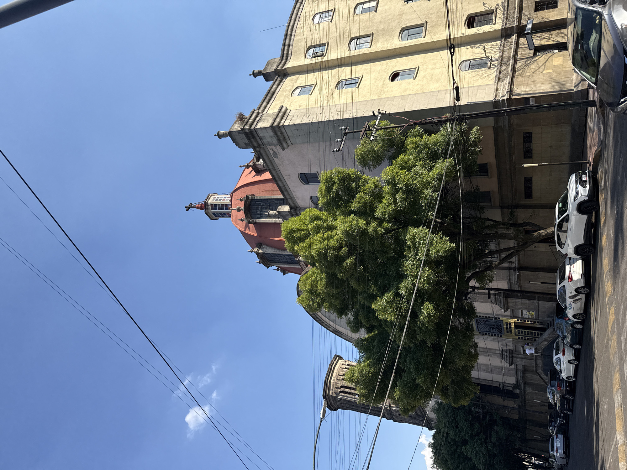 Mexico City street scene shows aged architecture, church dome