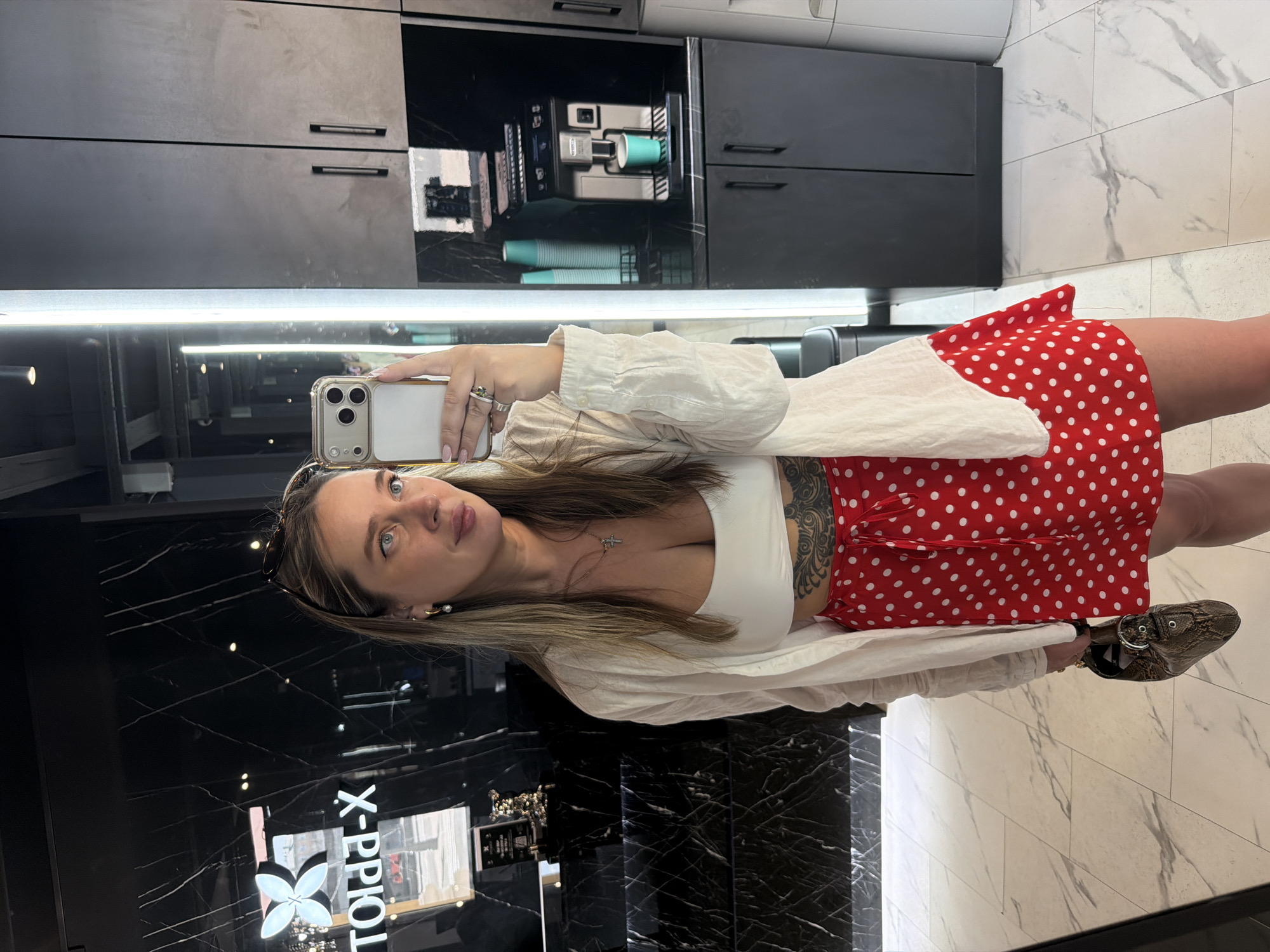 Woman takes selfie in Moscow salon wearing polka-dot outfit