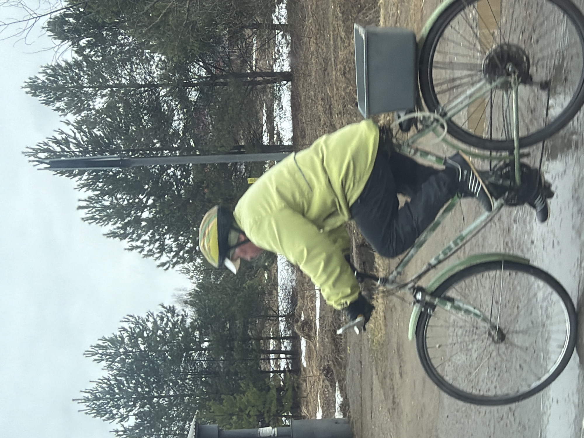 Cyclist rides muddy forest path amid snow patches in Russia