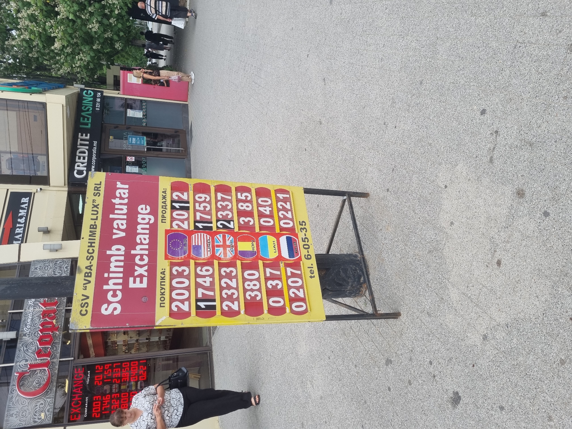 Street-level city scenes: trolleybus, currency exchange, and wet crosswalks