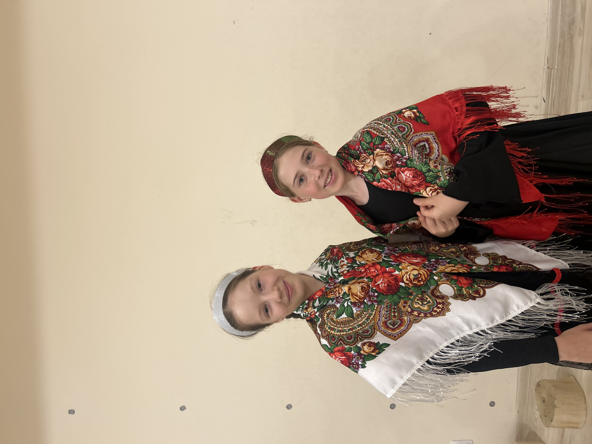 Floral scarves and black dresses, posed against a plain wall in Izhevsk