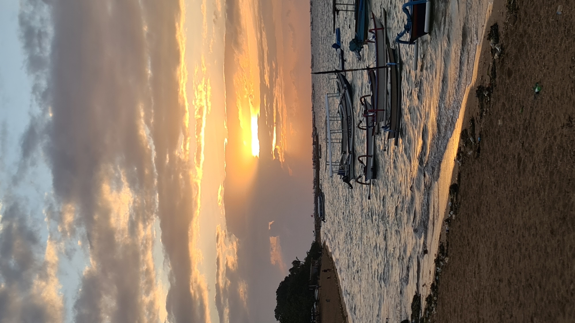 Bali beach at golden hour: boats, dogs, and a slow sunset