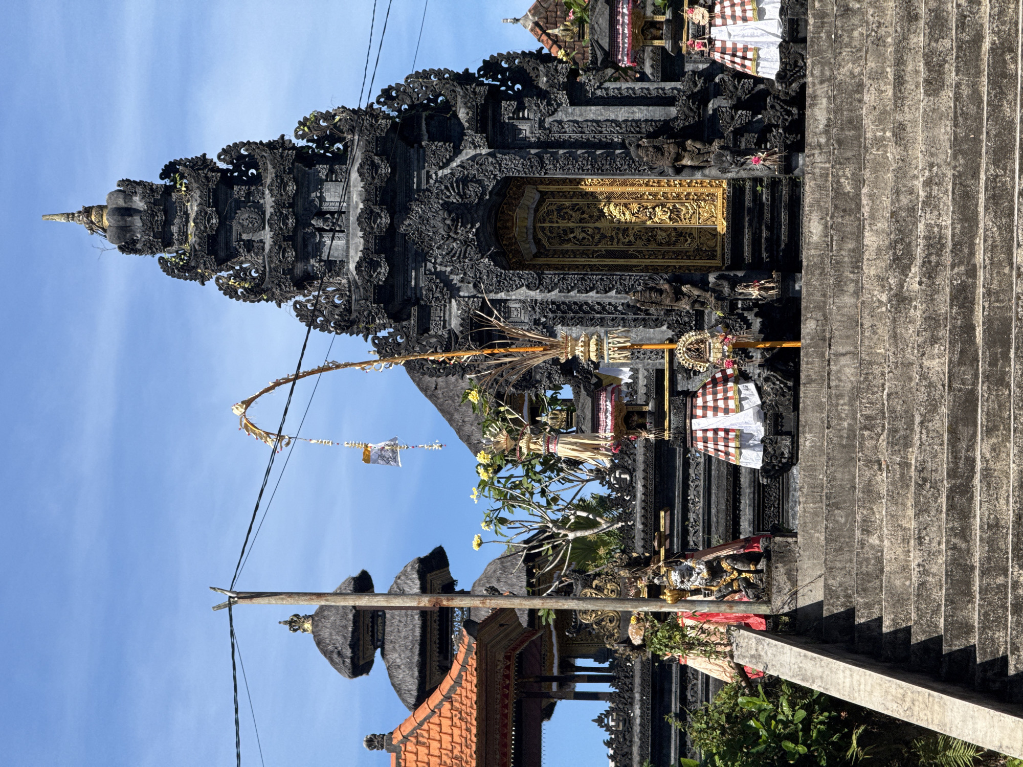Temple architecture and ocean play on a sunny Bali day
