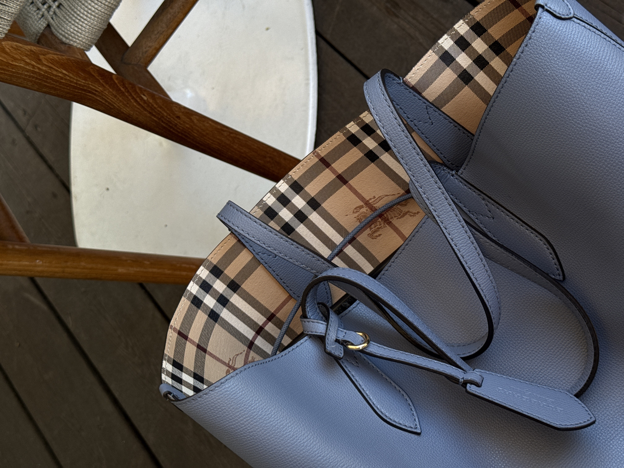 Blue leather tote bag spotted beside wooden chair indoors