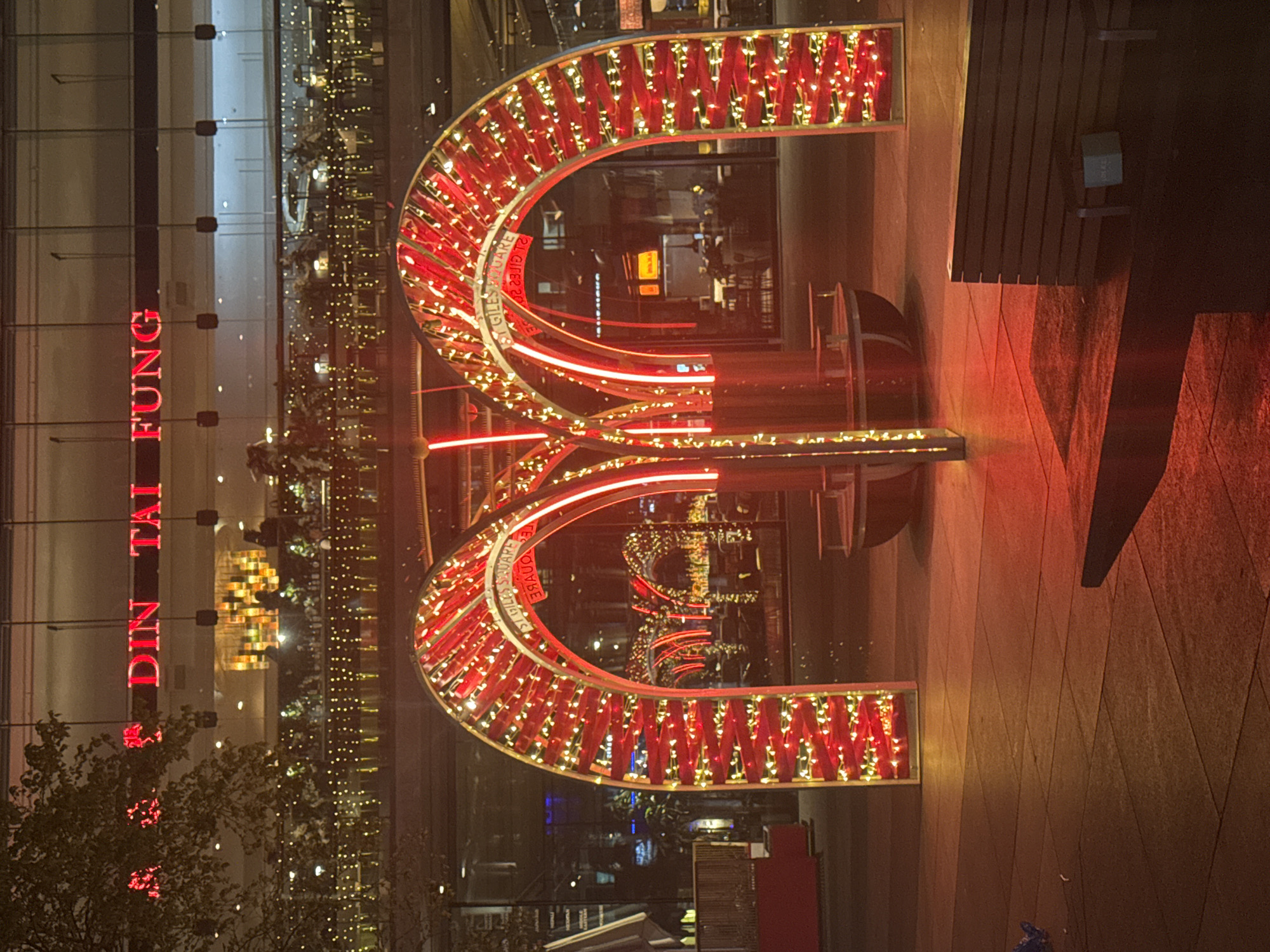 London nighttime scene features illuminated red arch and lit buildings