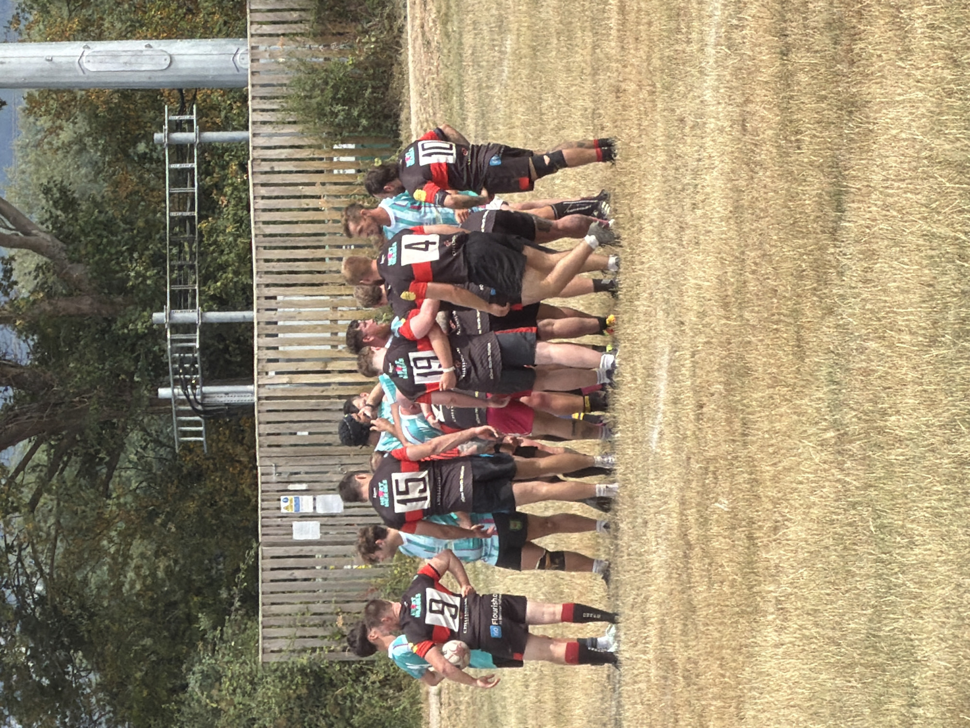 Rugby match underway on a dry Tewkesbury field