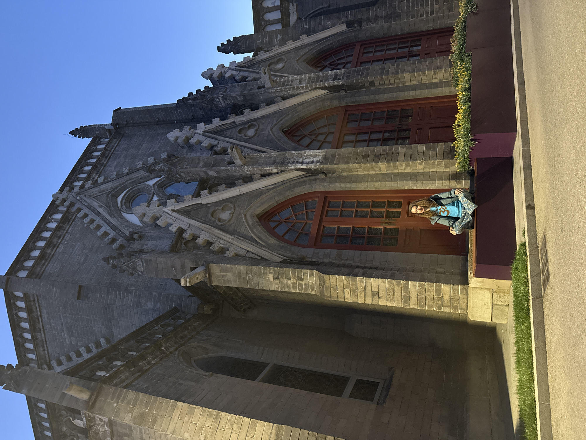 Woman sits outside historic Xishiku Cathedral in Beijing