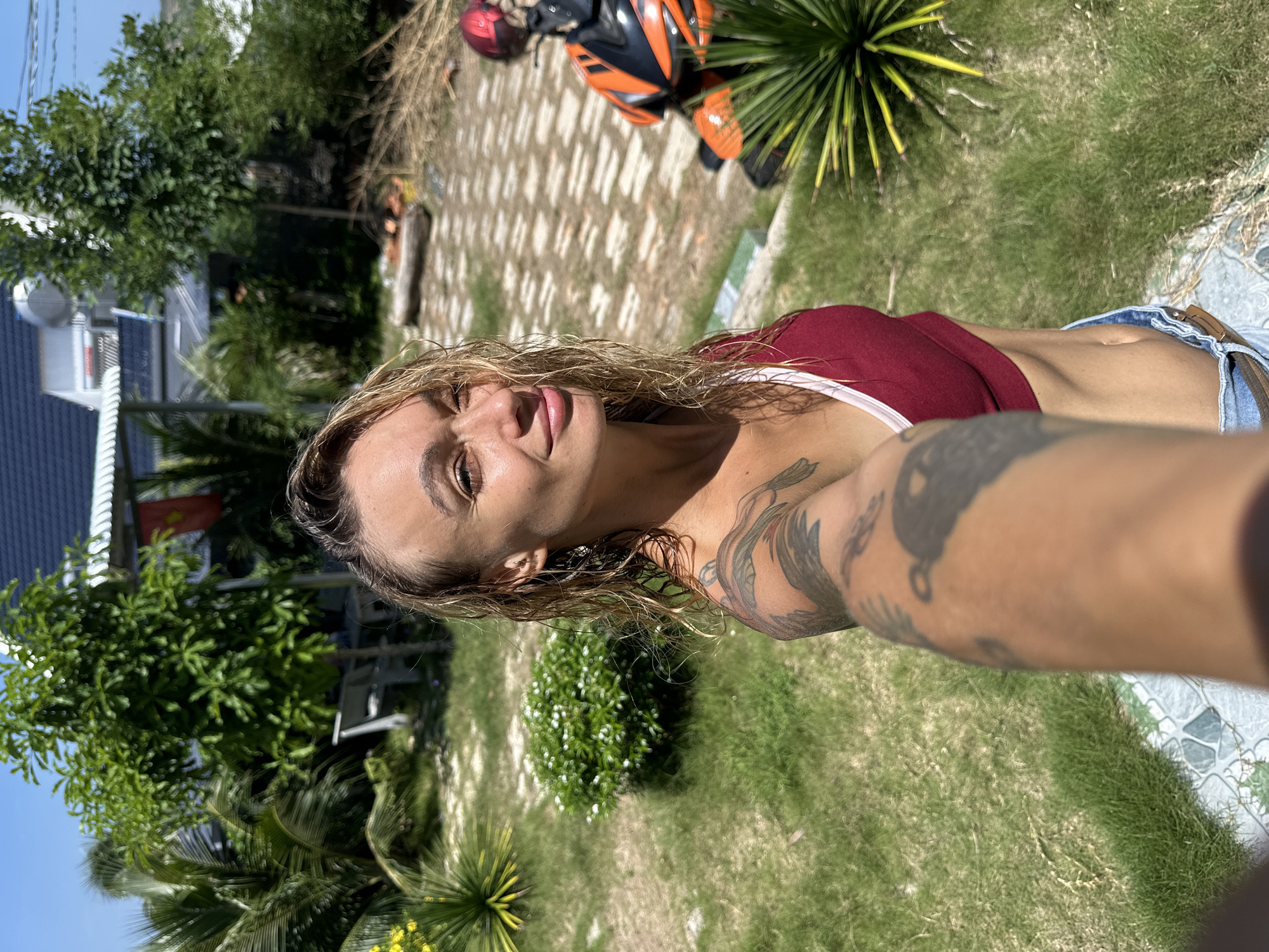 Woman takes selfie in Mũi Né with wet hair, tattoos