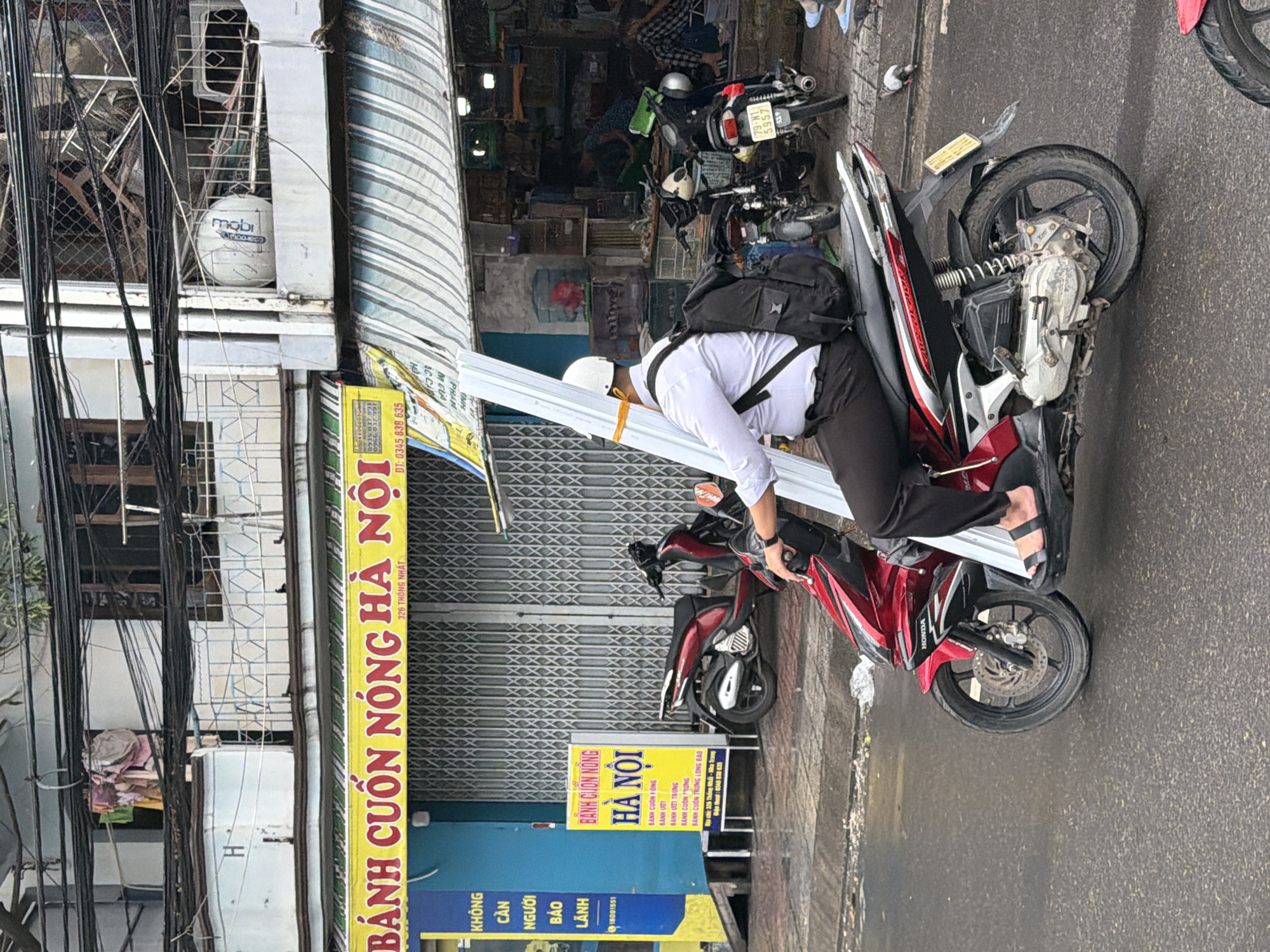 Wet morning motorcycle traffic through Nha Trang streets