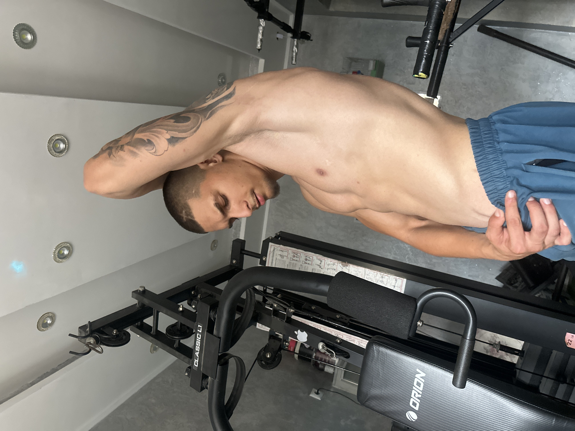 Tattooed man documents workout routine at gym during afternoon session