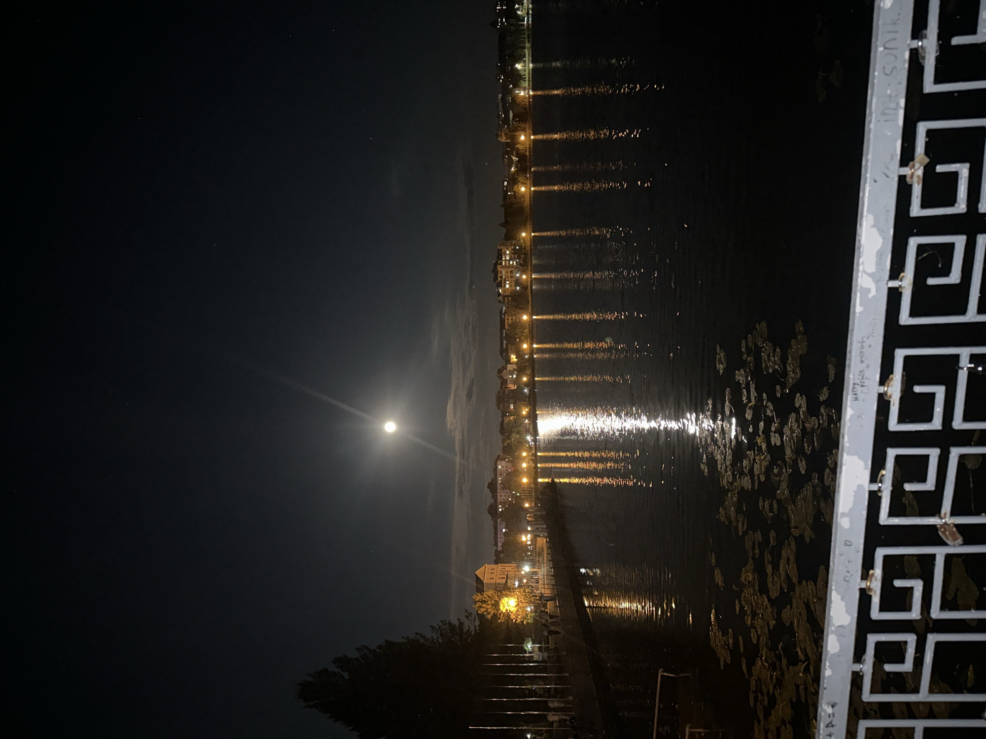 Full moon night at Ternopil Pond's lakeside gazebo